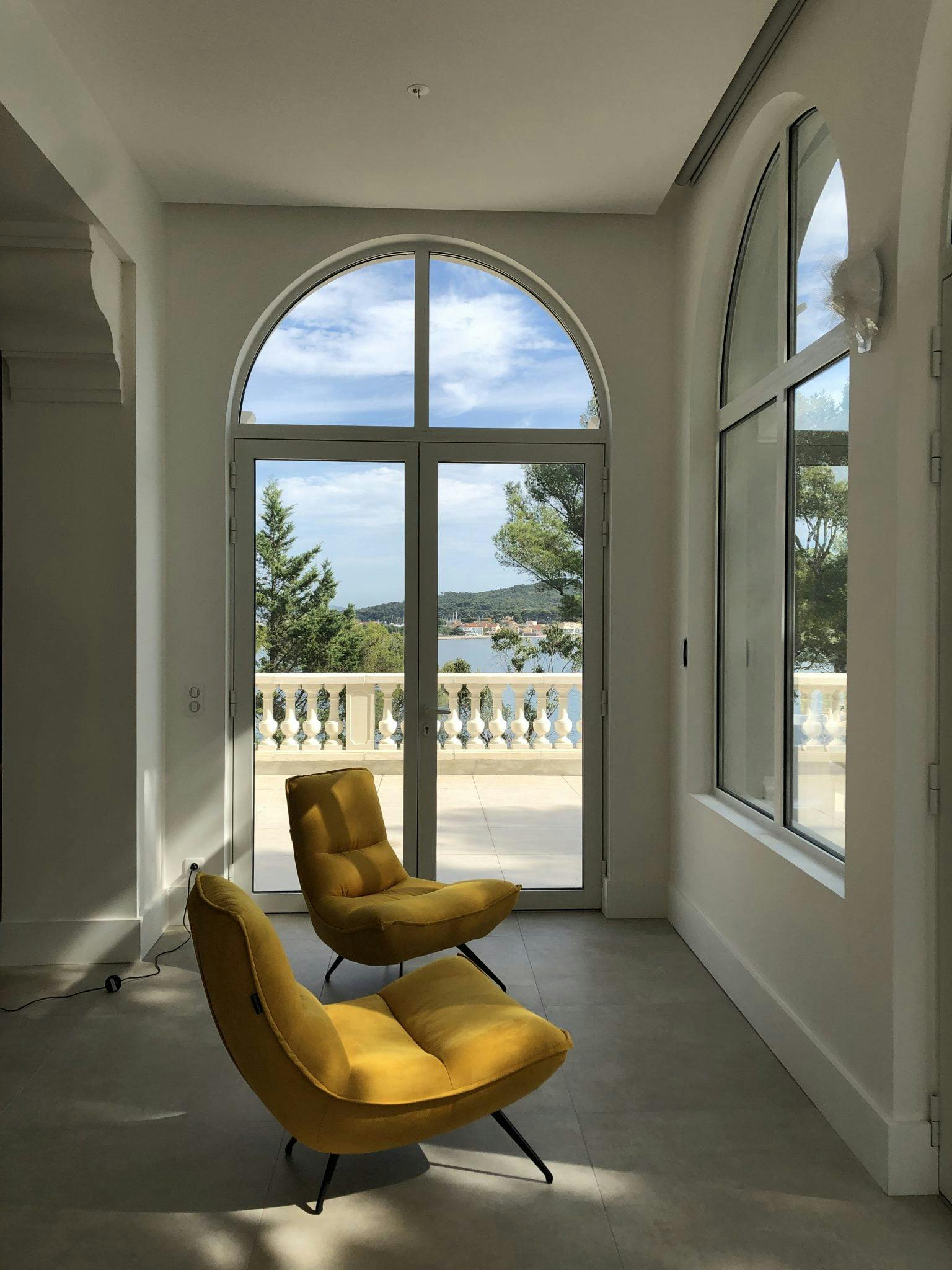 Mustard yellow armchair and large arched window