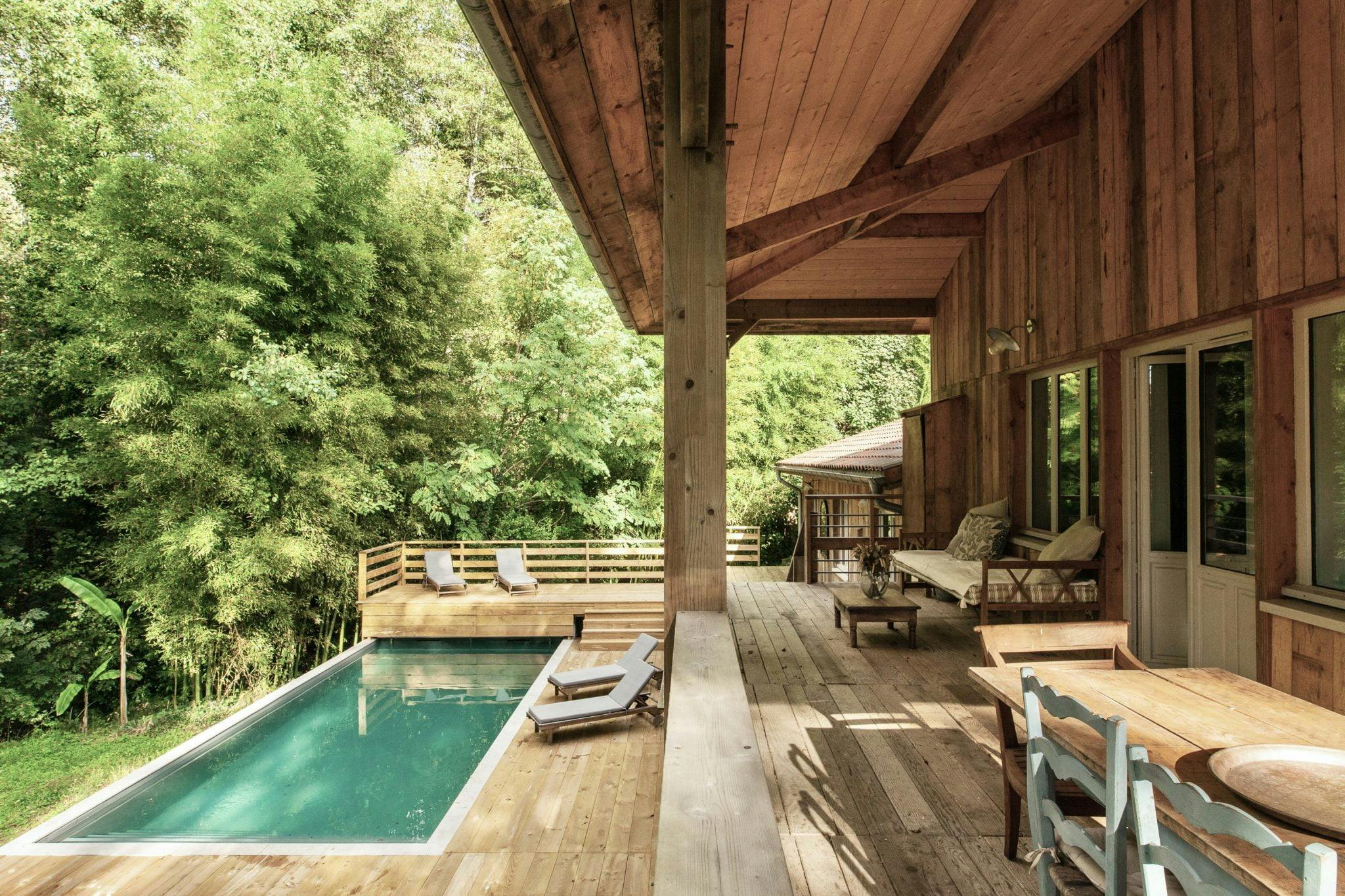 large wooden terrace with access to the pool