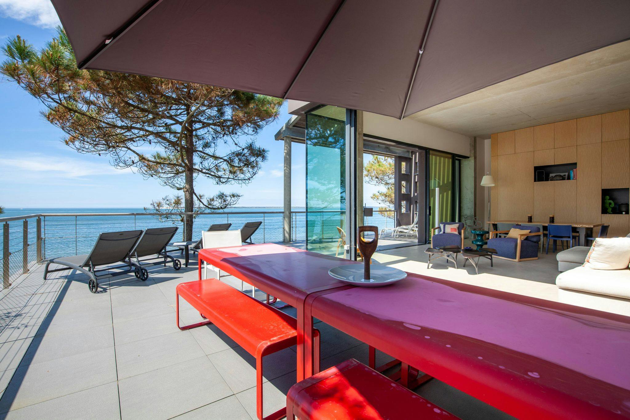 grande table rouge sur la terrasse pour déjeuner