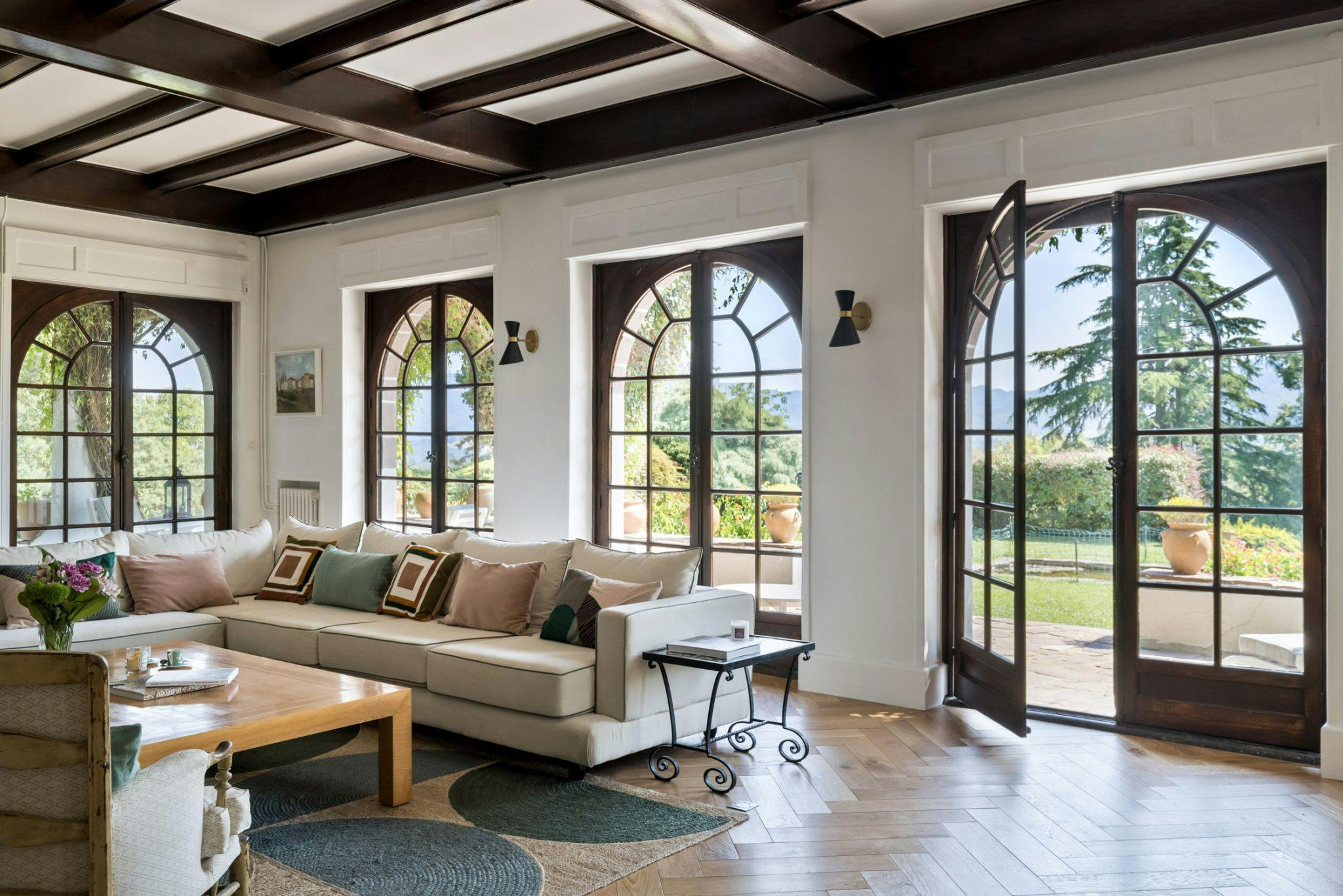 living room with large arched windows overlooking the garden