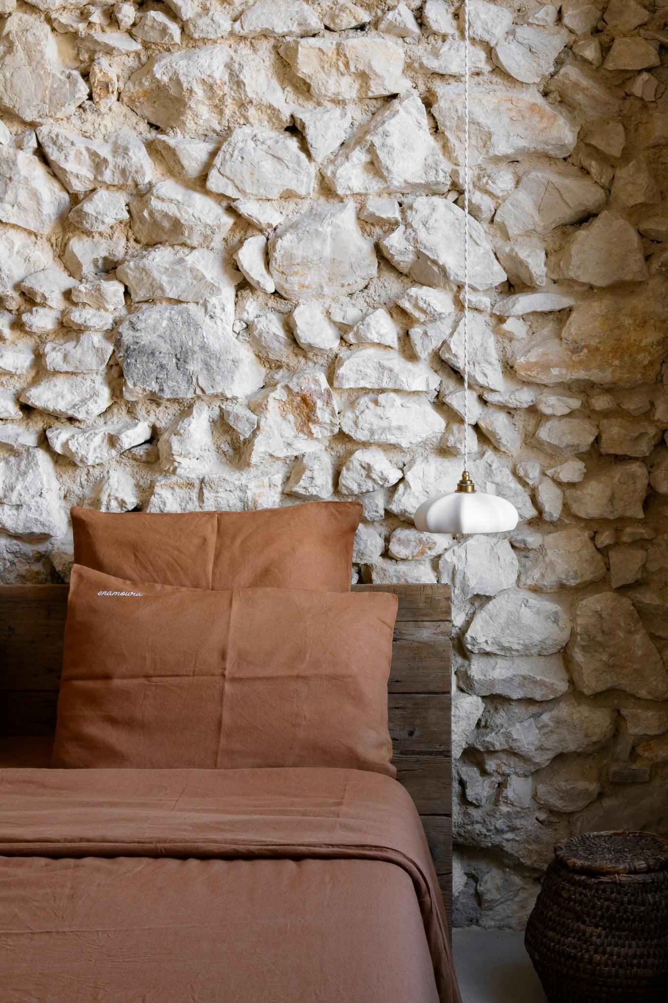 bedroom with chestnut tones and stone wall
