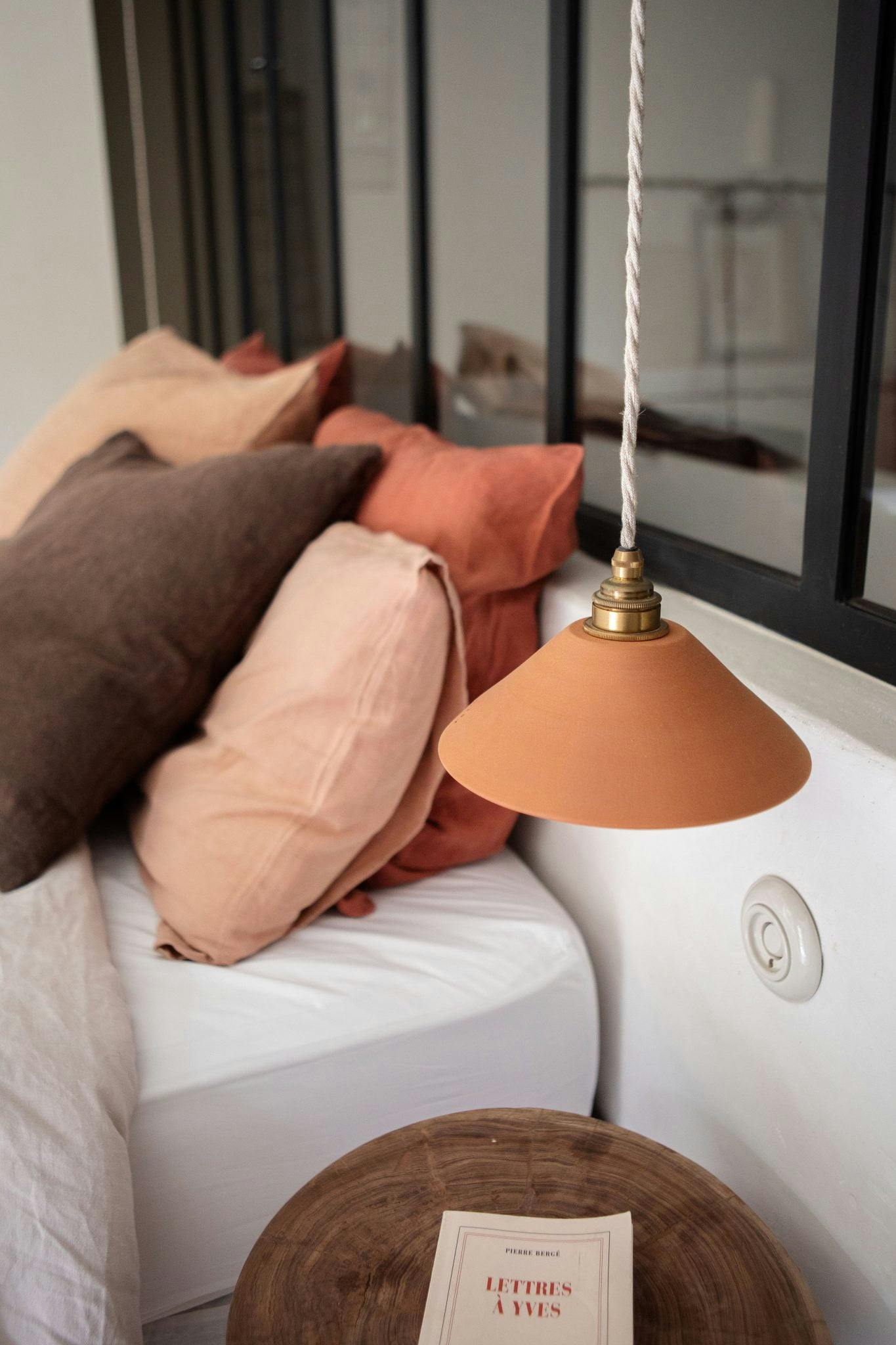 bedroom details: coloured cushion and hanging lamp