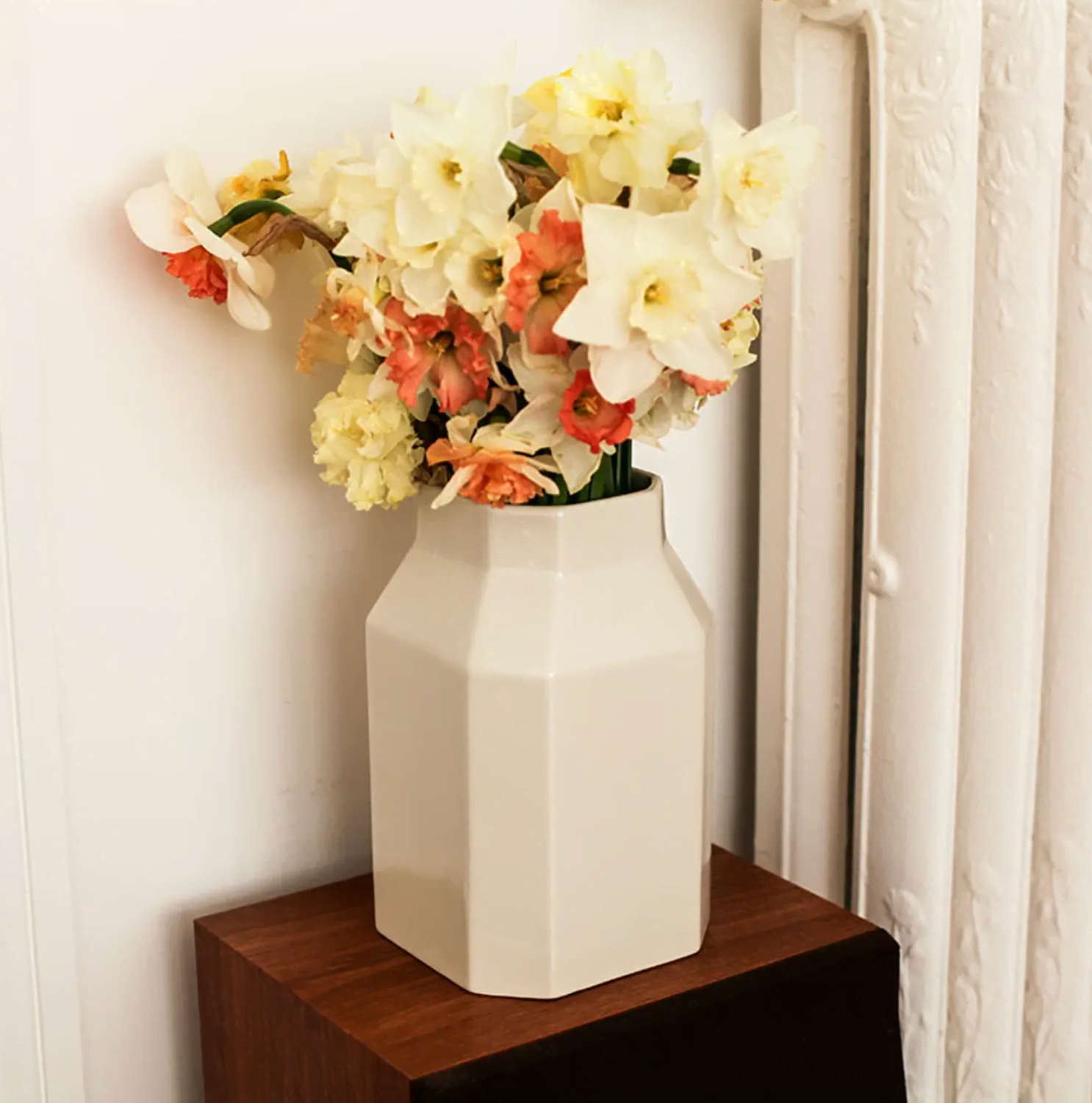 cream vase with colorful flowers