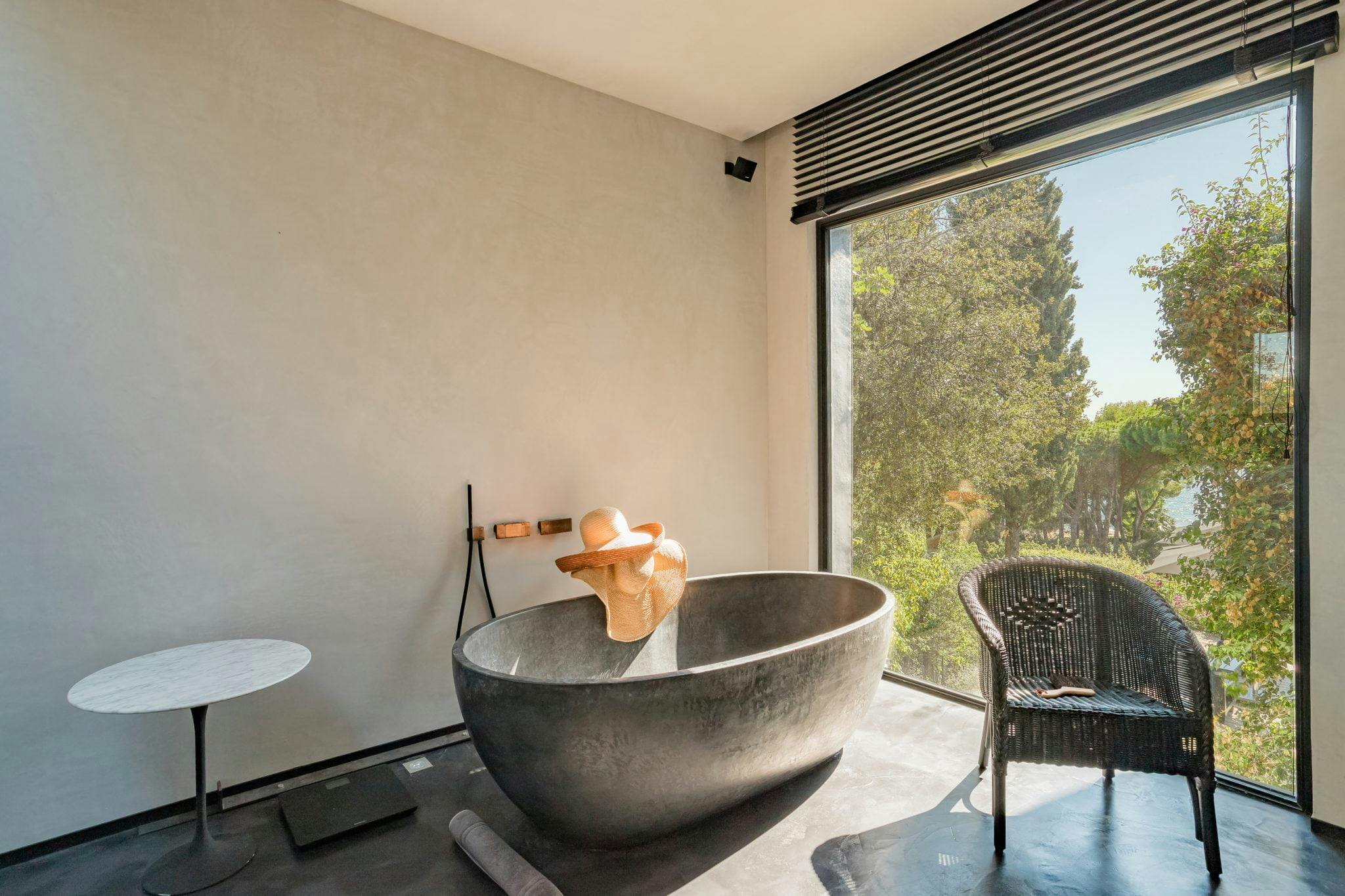 anthracite grey bath with view of the trees and the sea