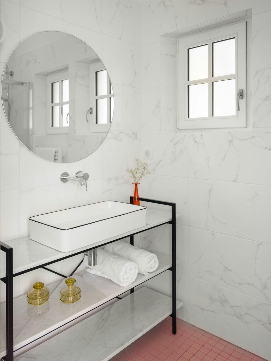 white bathroom with washbasin and round mirror