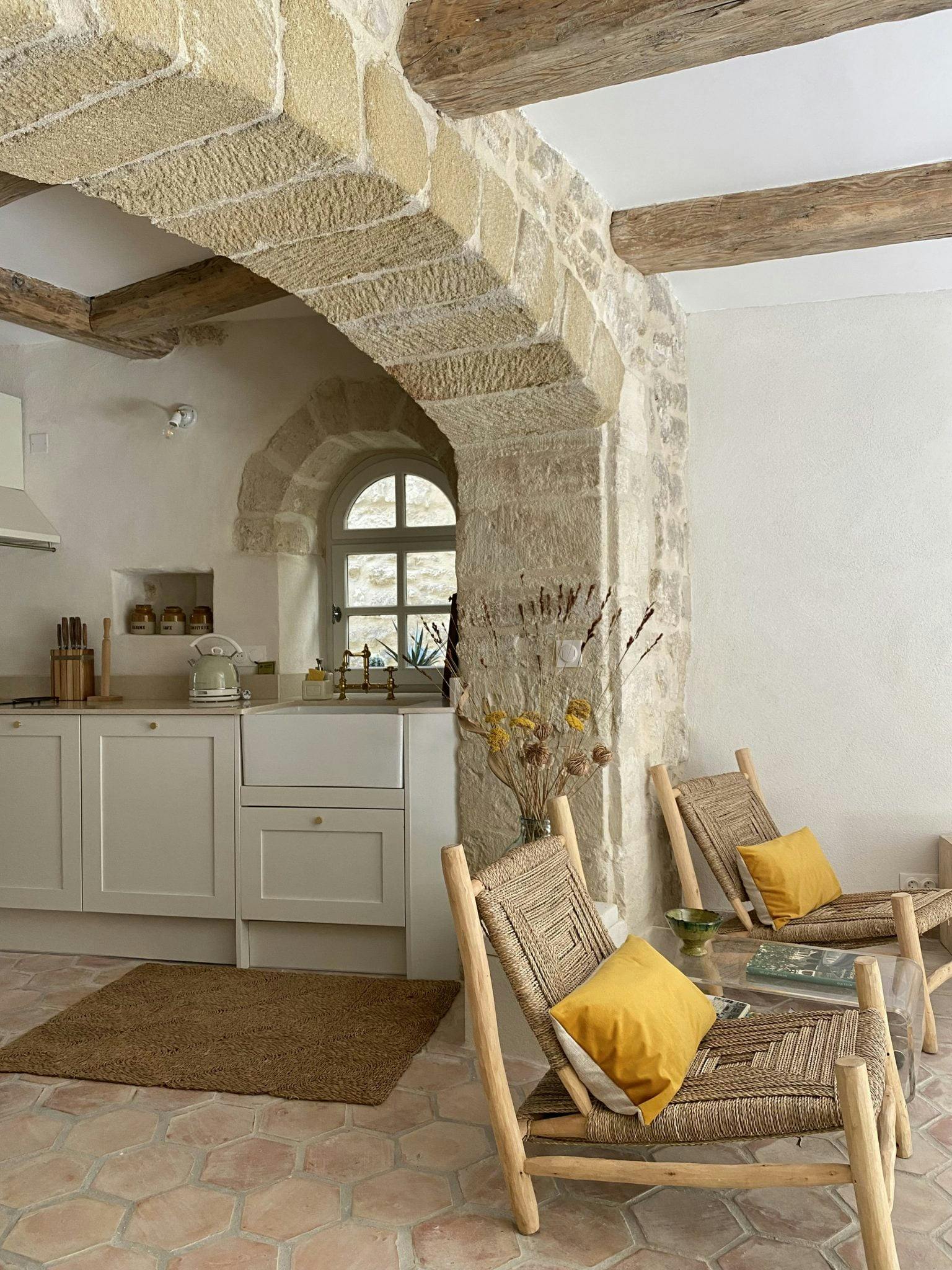 Jonction entre la cuisine et le salon, à travers une grande arche en pierre