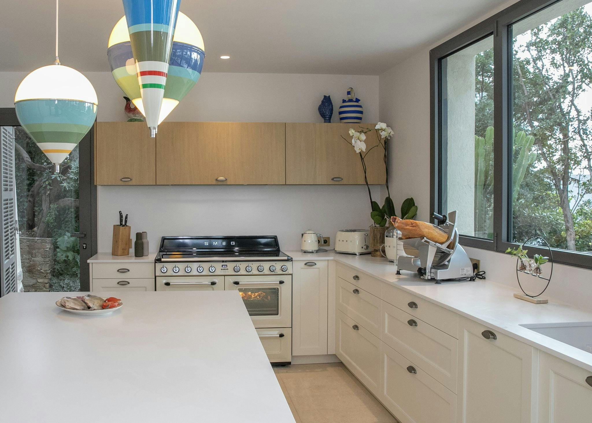Kitchen with large worktop, top-of-the-range appliances in cream tones and pendant lights