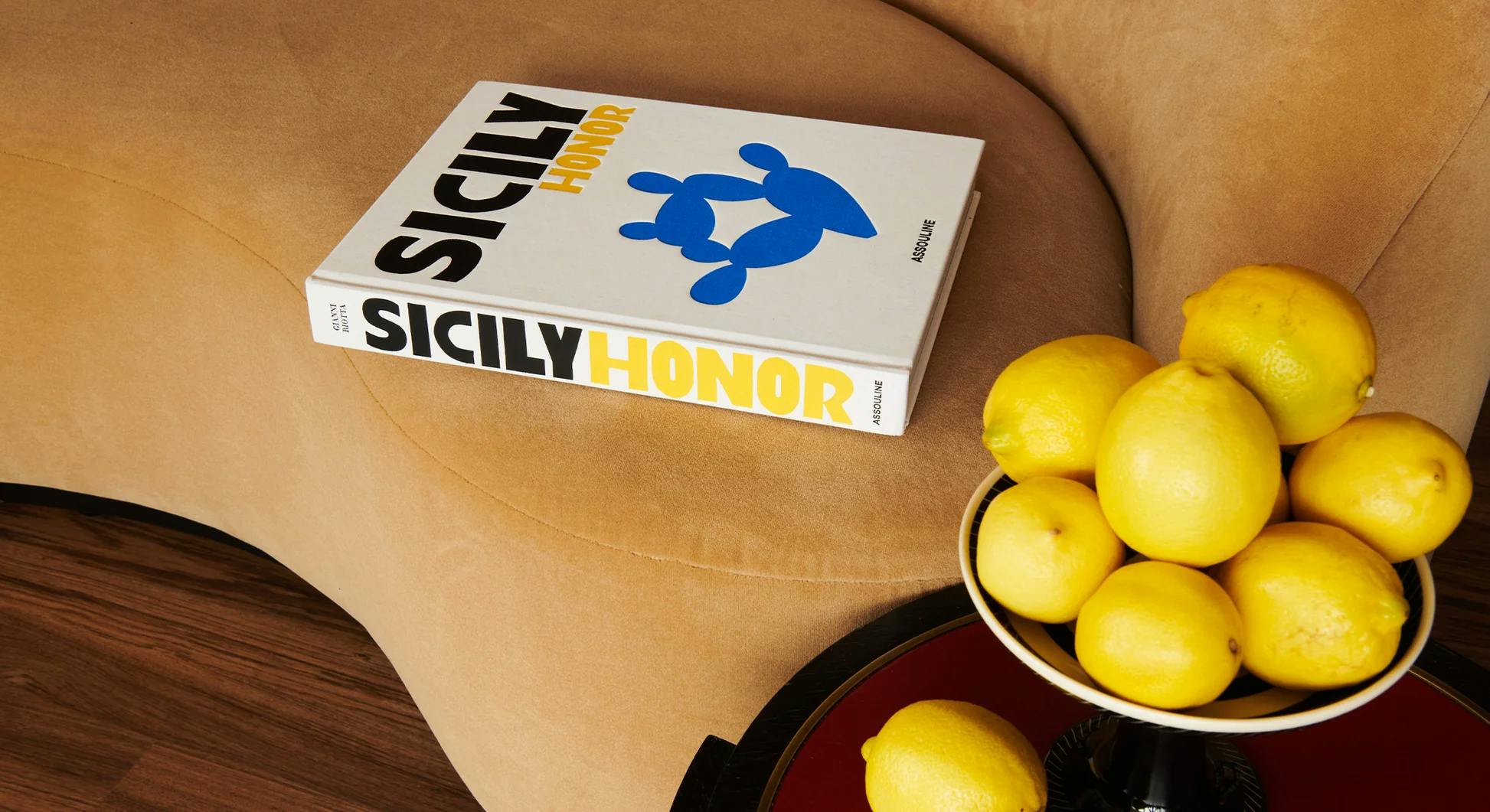 beautiful "sicily honor" book on a sofa, lemons in foreground