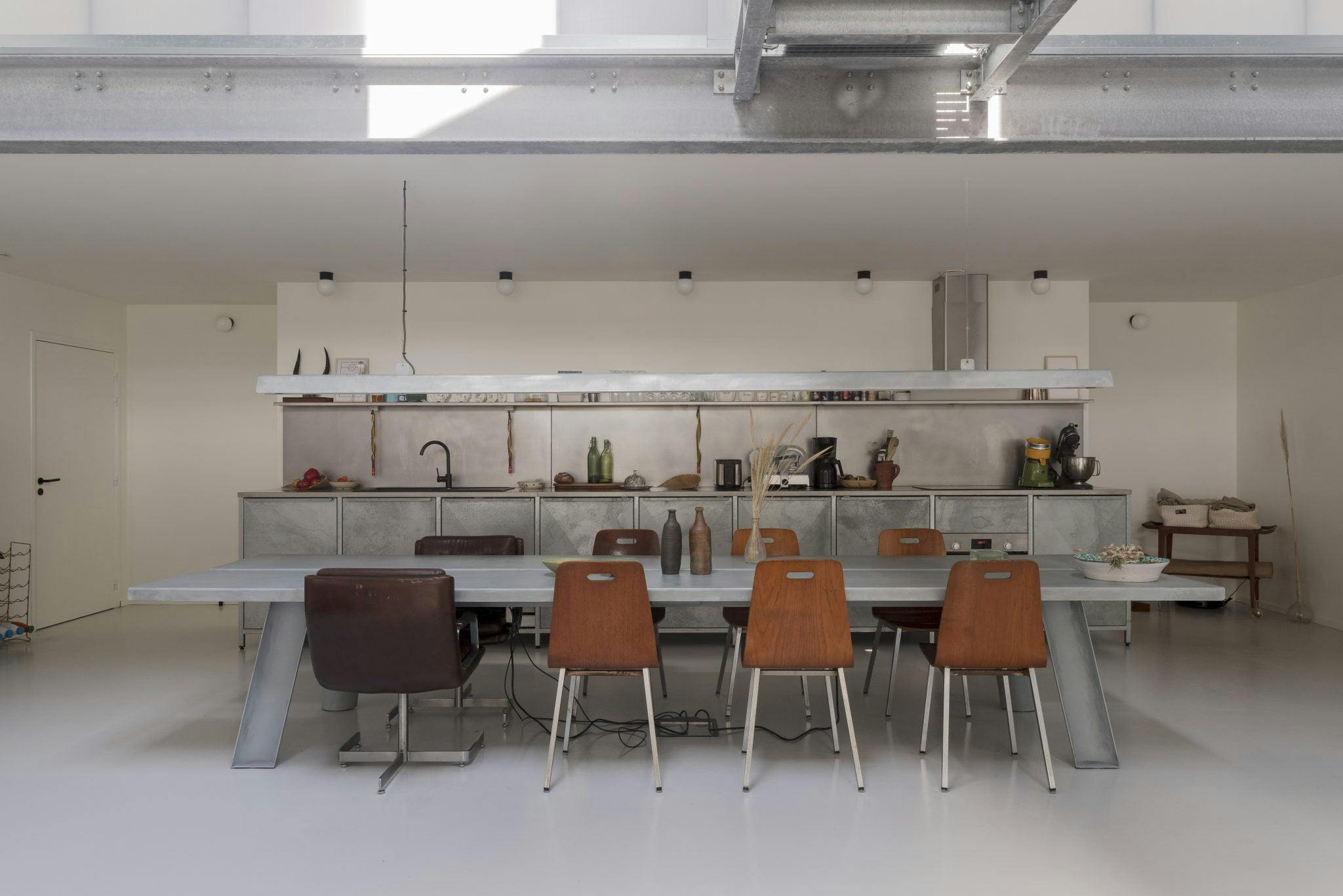 The stainless steel kitchen and its industrial dining table