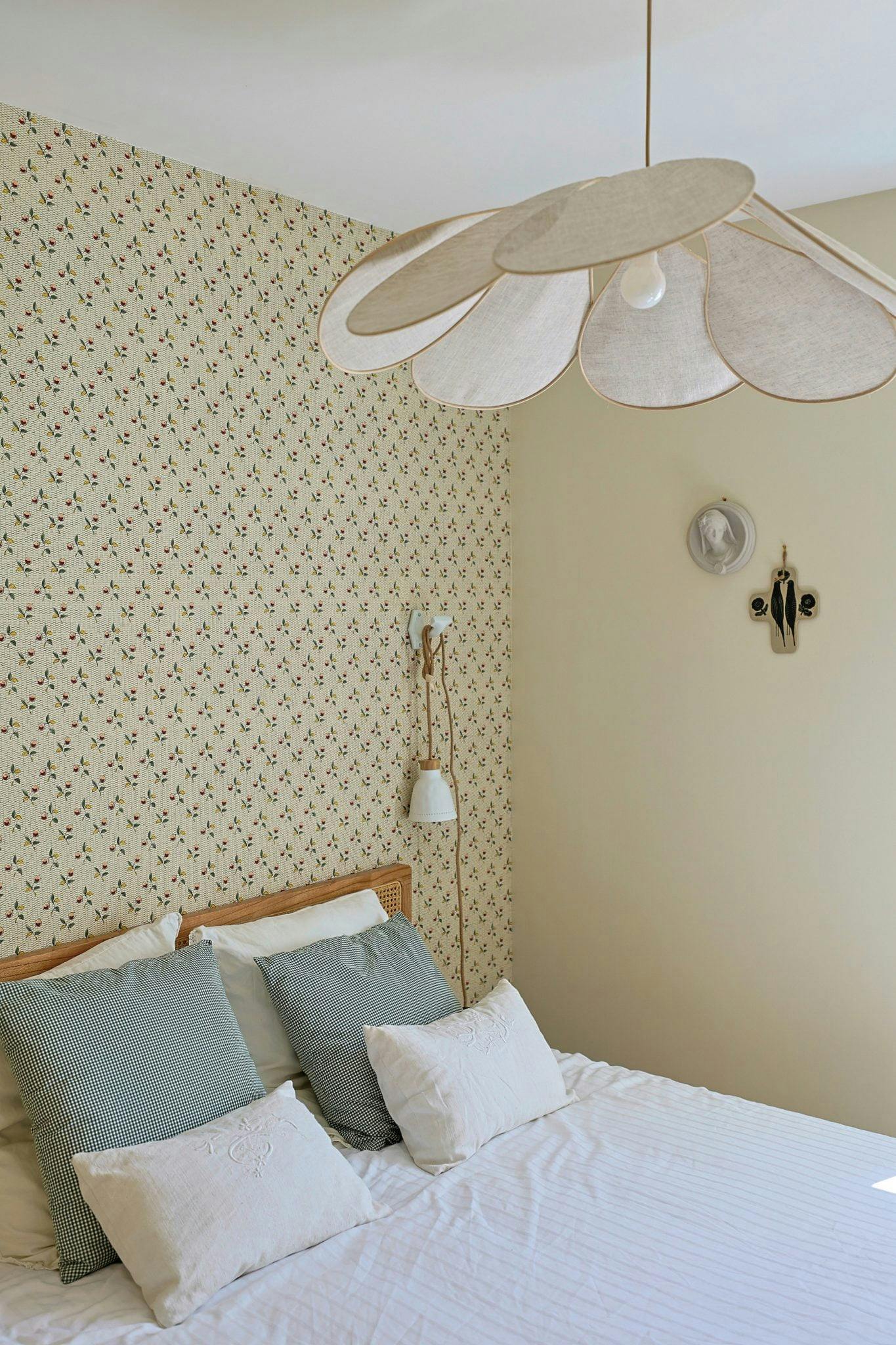 Lit et chambre aux murs couverts d'un papier peint fleuri