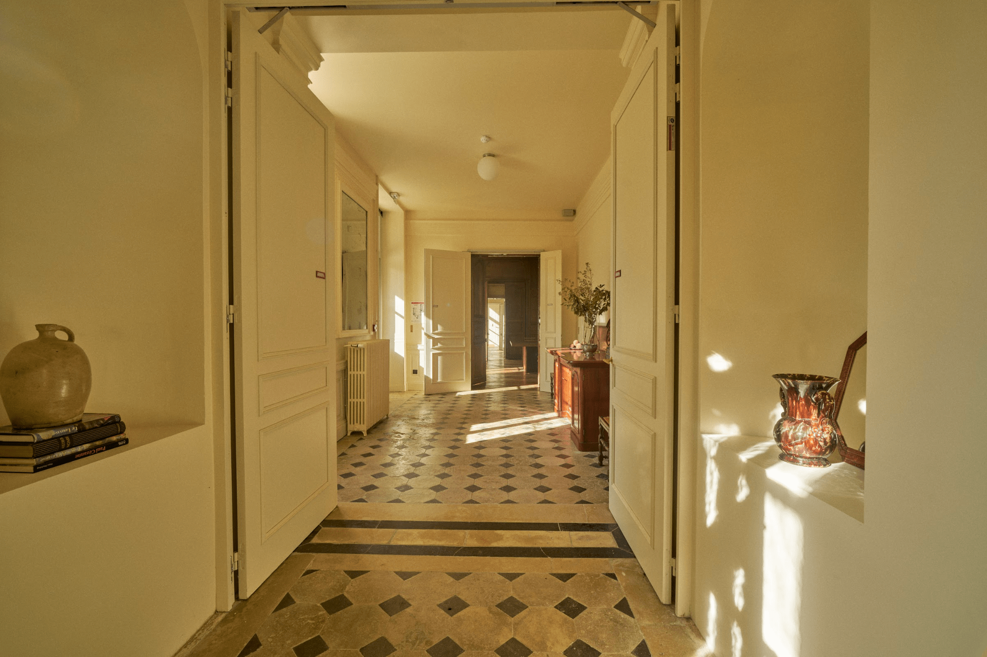 L'un des couloirs du château : carrelage blanc et bleu, murs blancs