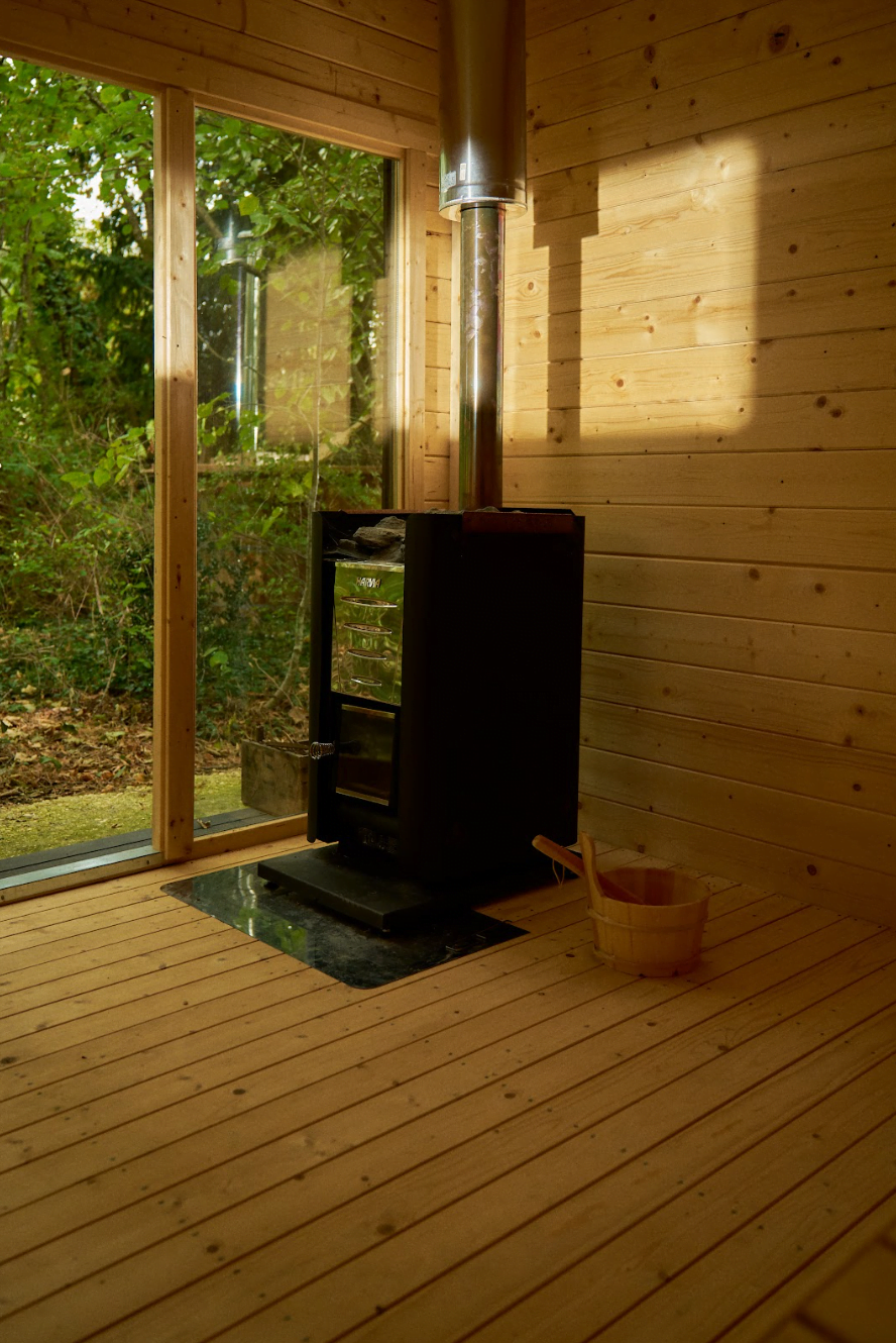 Le sauna extérieur du château, tout en bois, au milieu des arbres