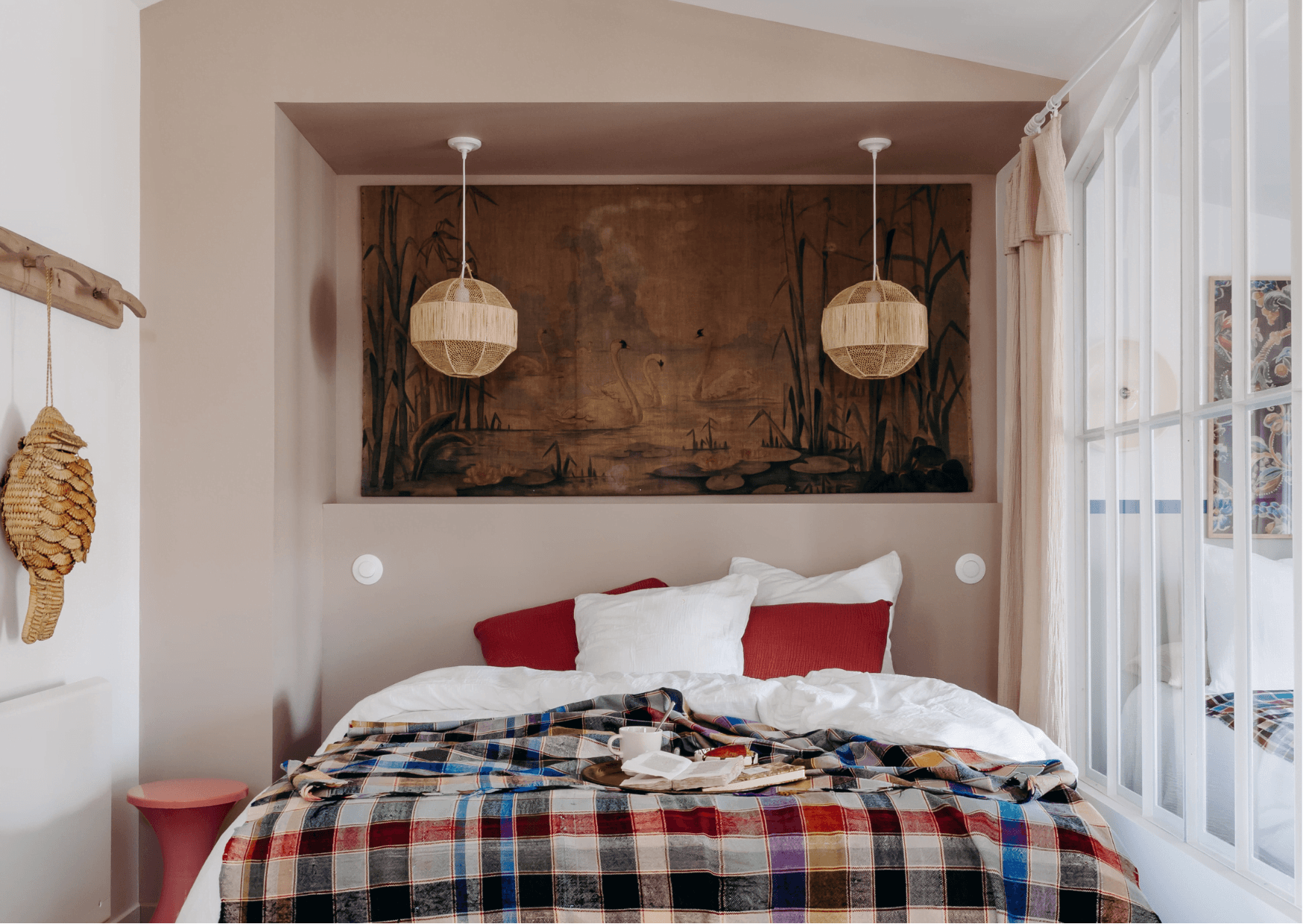 The room: checkered bedspread, pendant lights, glass door