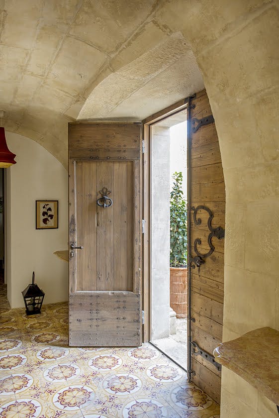 La porte d'entrée en bois du Mas le Gaudre, carrelage au sol et plafond en pierre