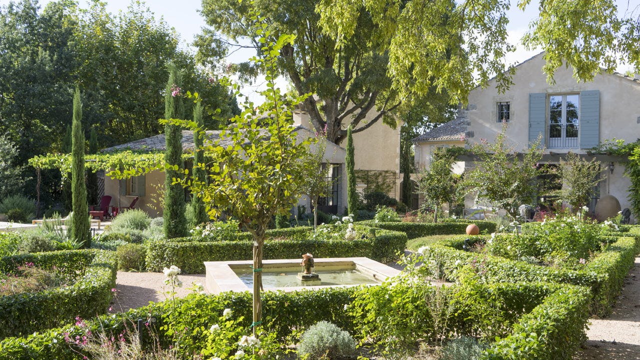 L'un des jardins à la française du Mas le Gaudre : buissons, arbres et fontaine
