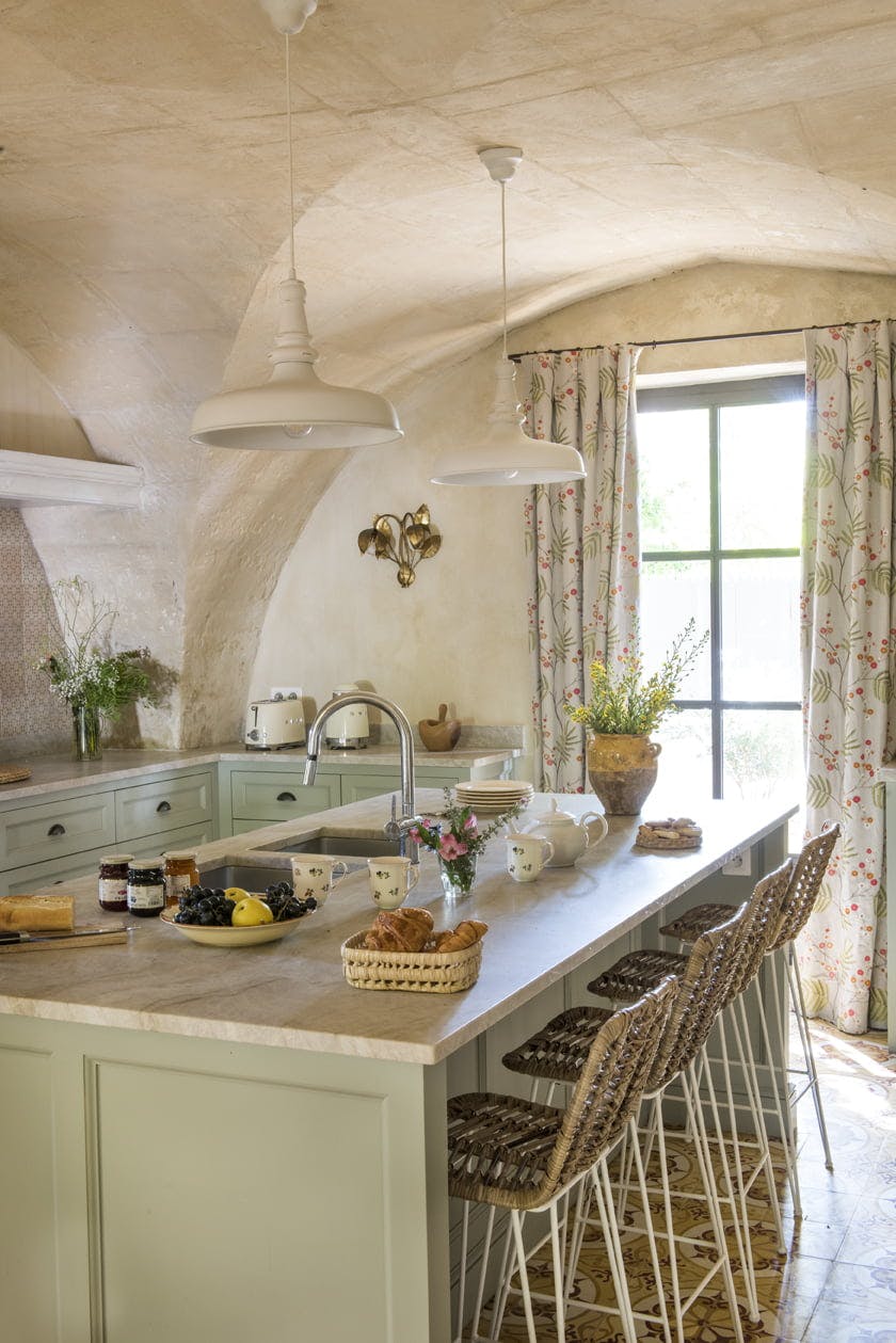 La cuisine du Mas le Gaudre : la voûte creusée dans la pierre, l'îlot central et les murs en pierre