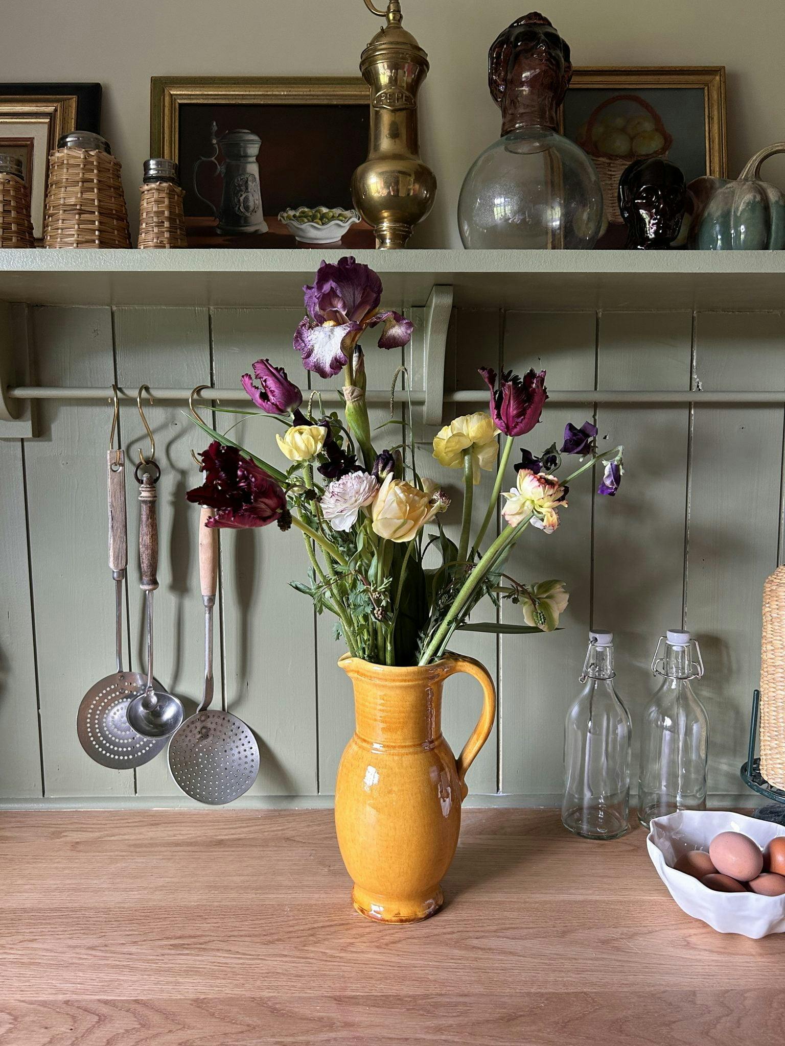 Bouquet de fleurs dans un vase jaune dans la cuisine