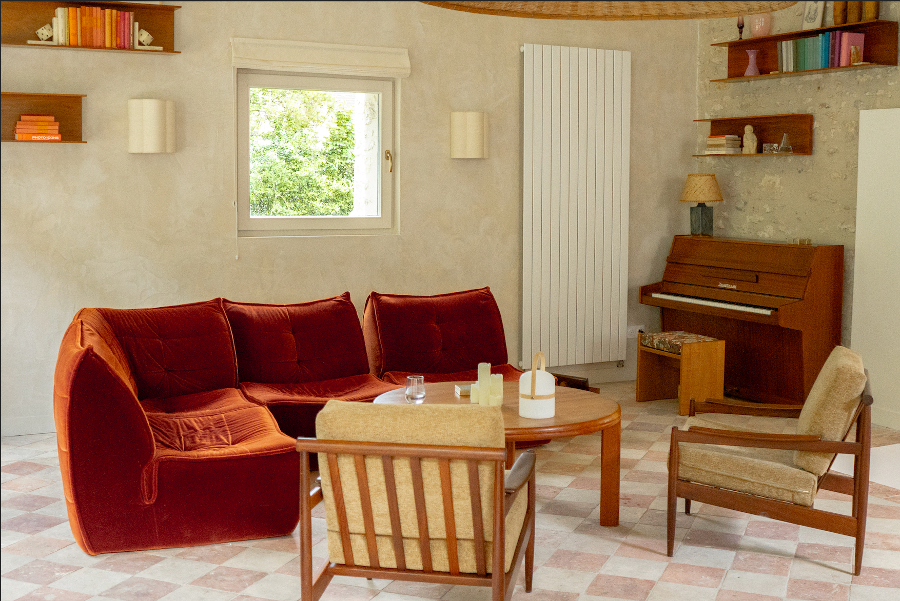 The living room of La Source: wooden armchairs and red sofas
