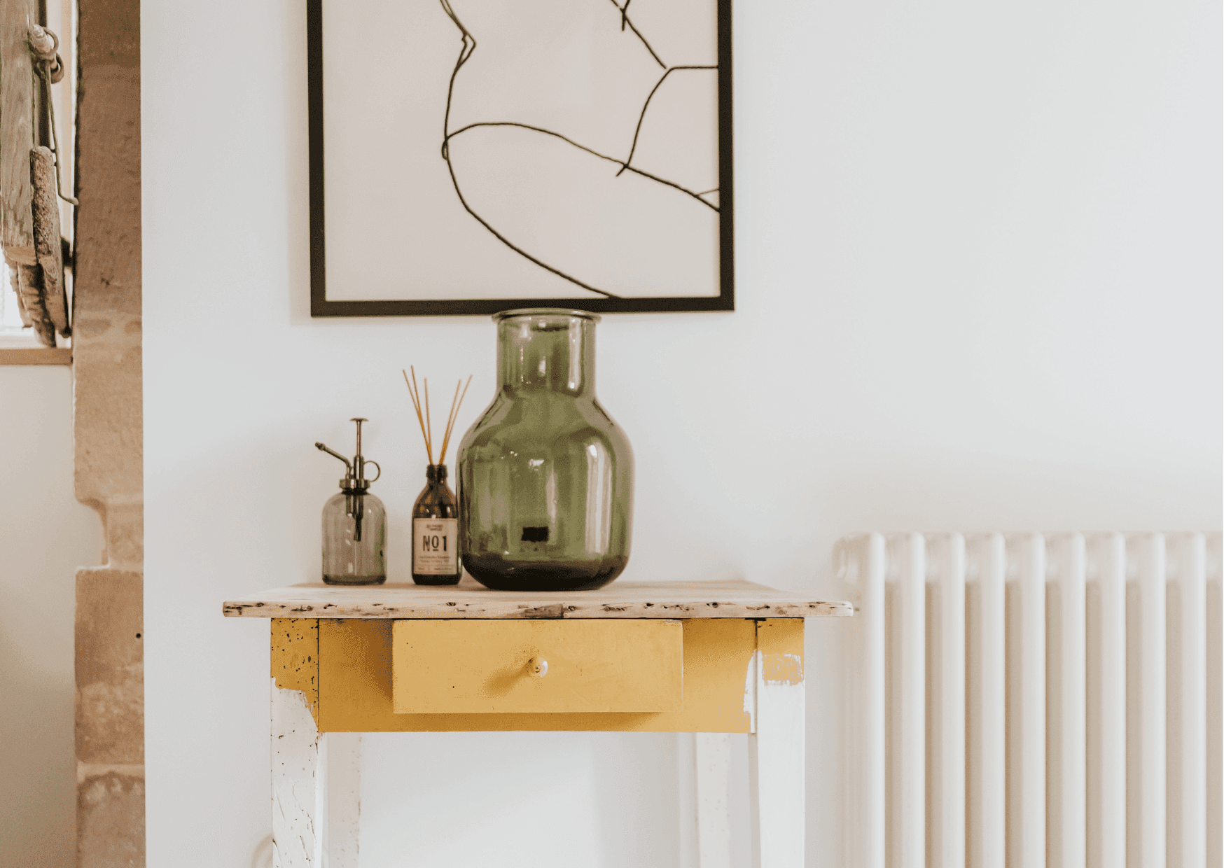 Détail d'une petite table : vase, tableau au mur