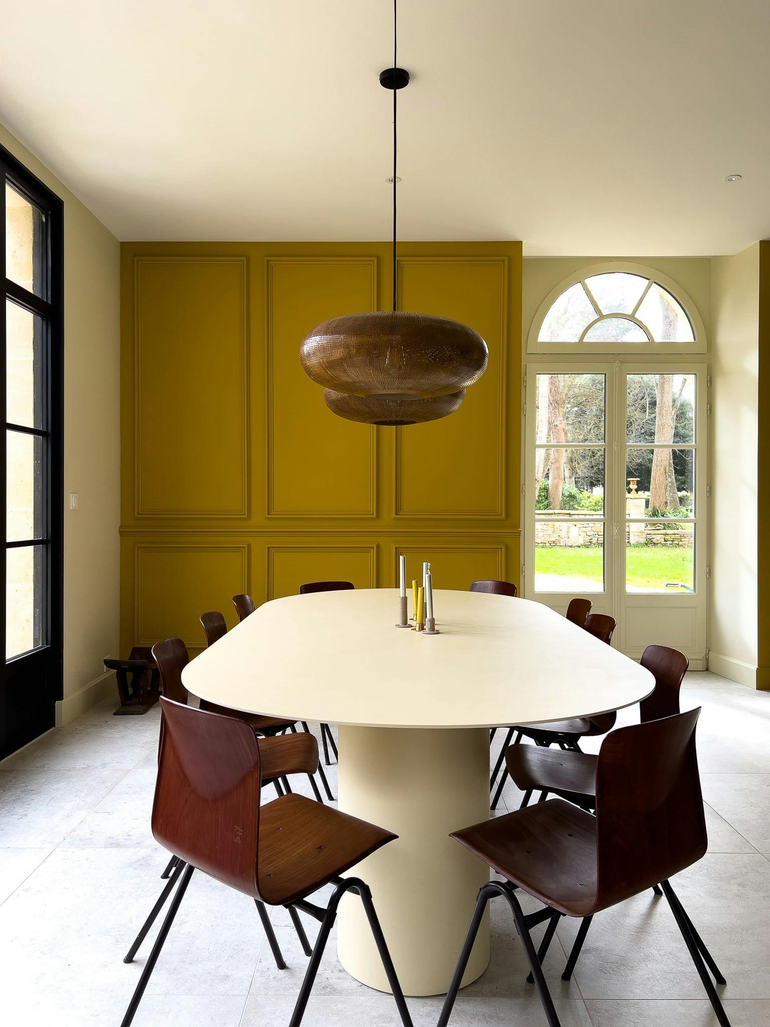 The dining room of the château: white table, wooden chairs.