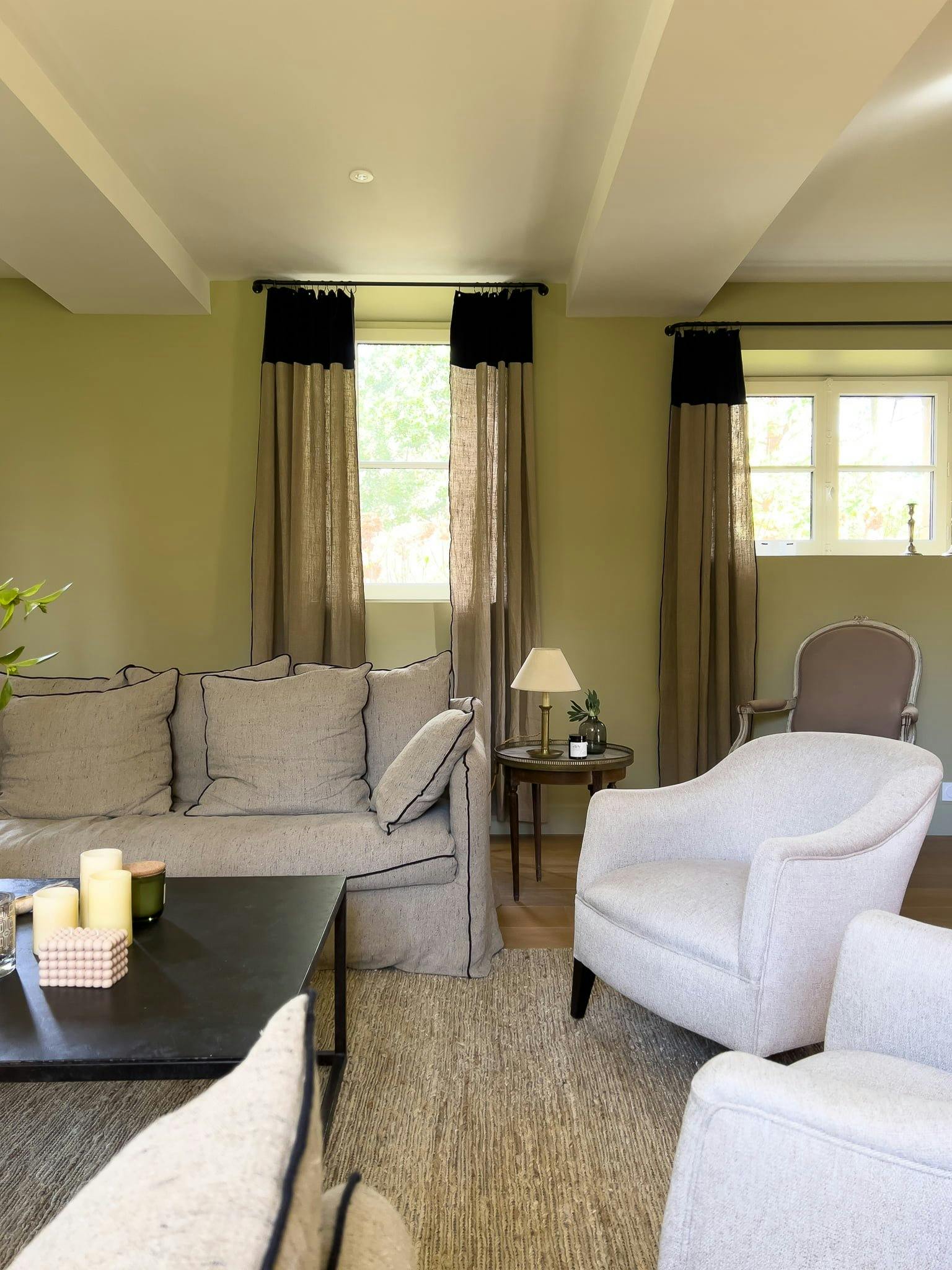 One of the lounges of the château, with a gray sofa and white armchairs.