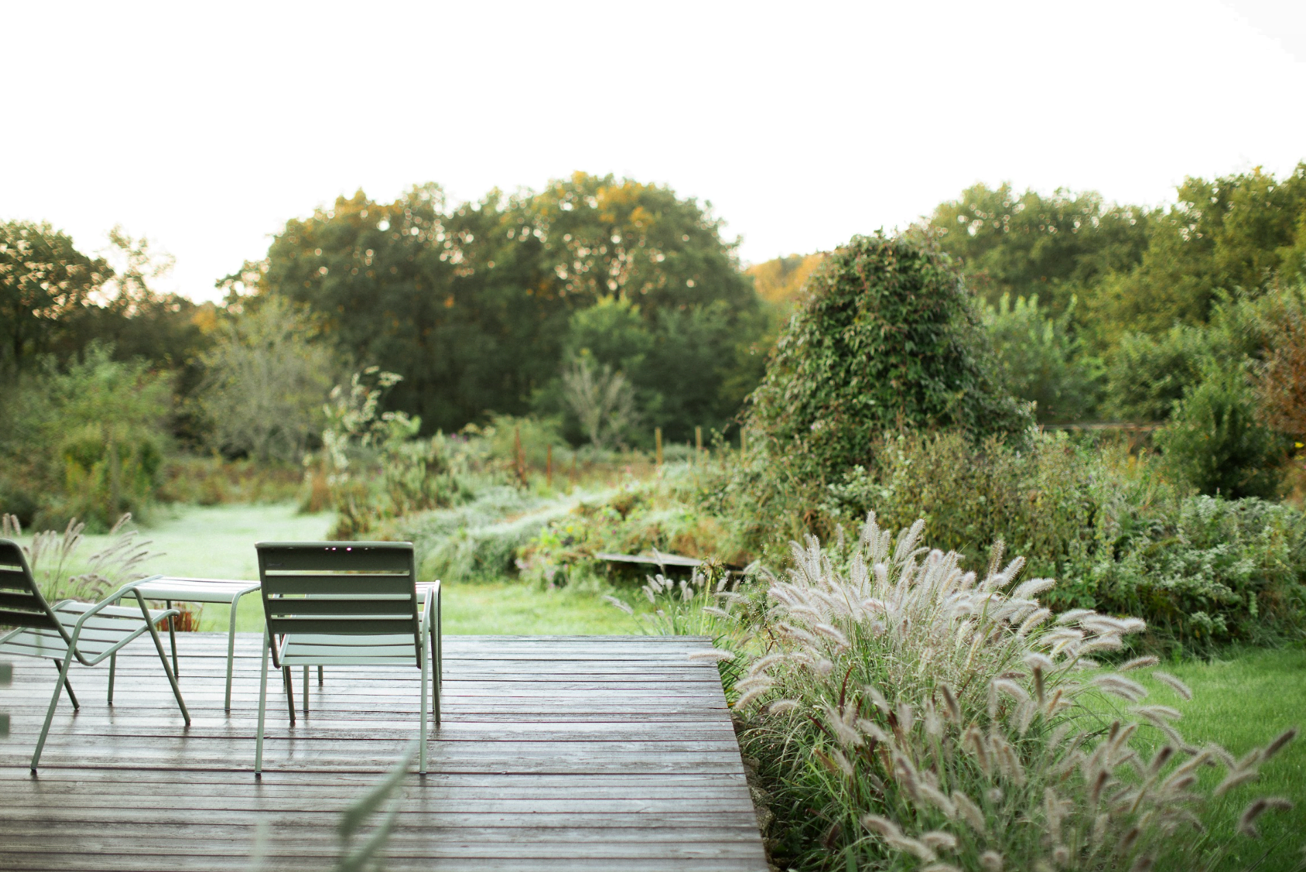 La terrasse en bois donnant sur le jardin, chaises vertes