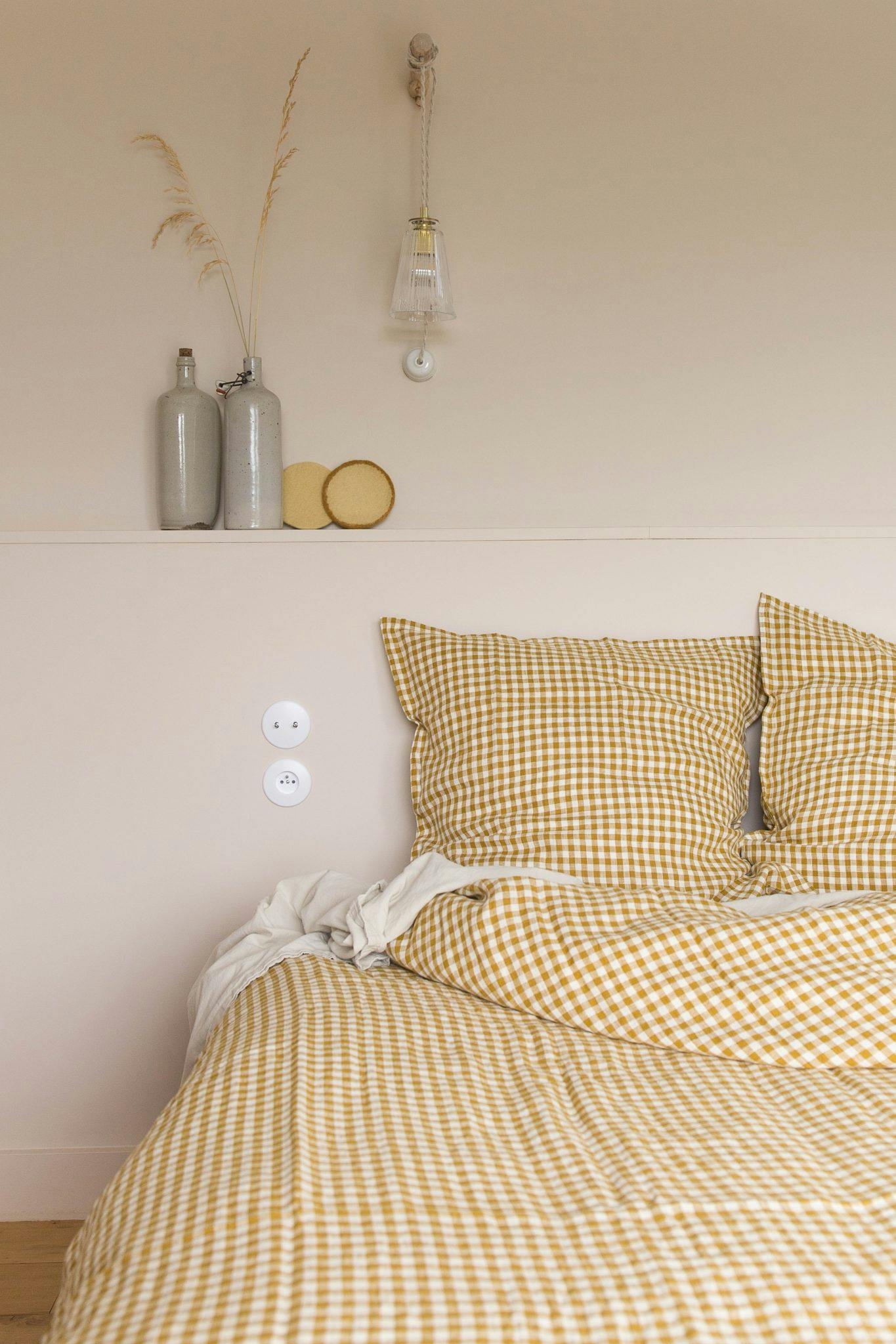 One of the bedrooms: bed, striped sheets, vases