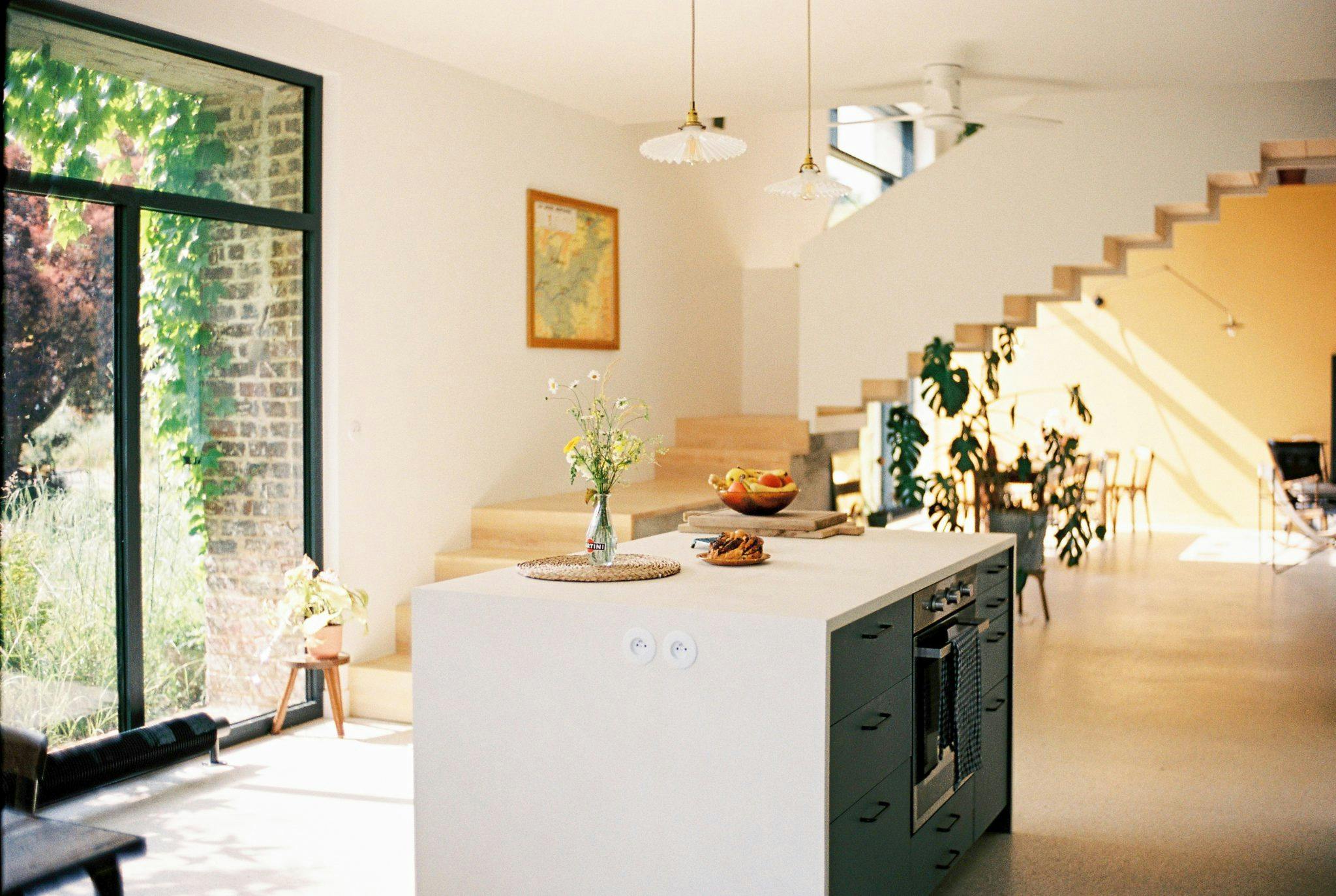 The kitchen: central island, pendant lights, plants