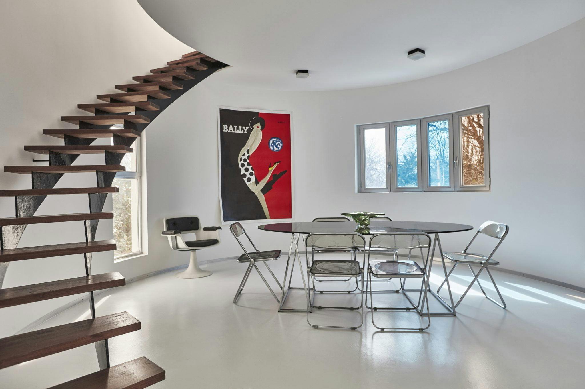 Dining room of the villa: table, chairs, staircase, paintings