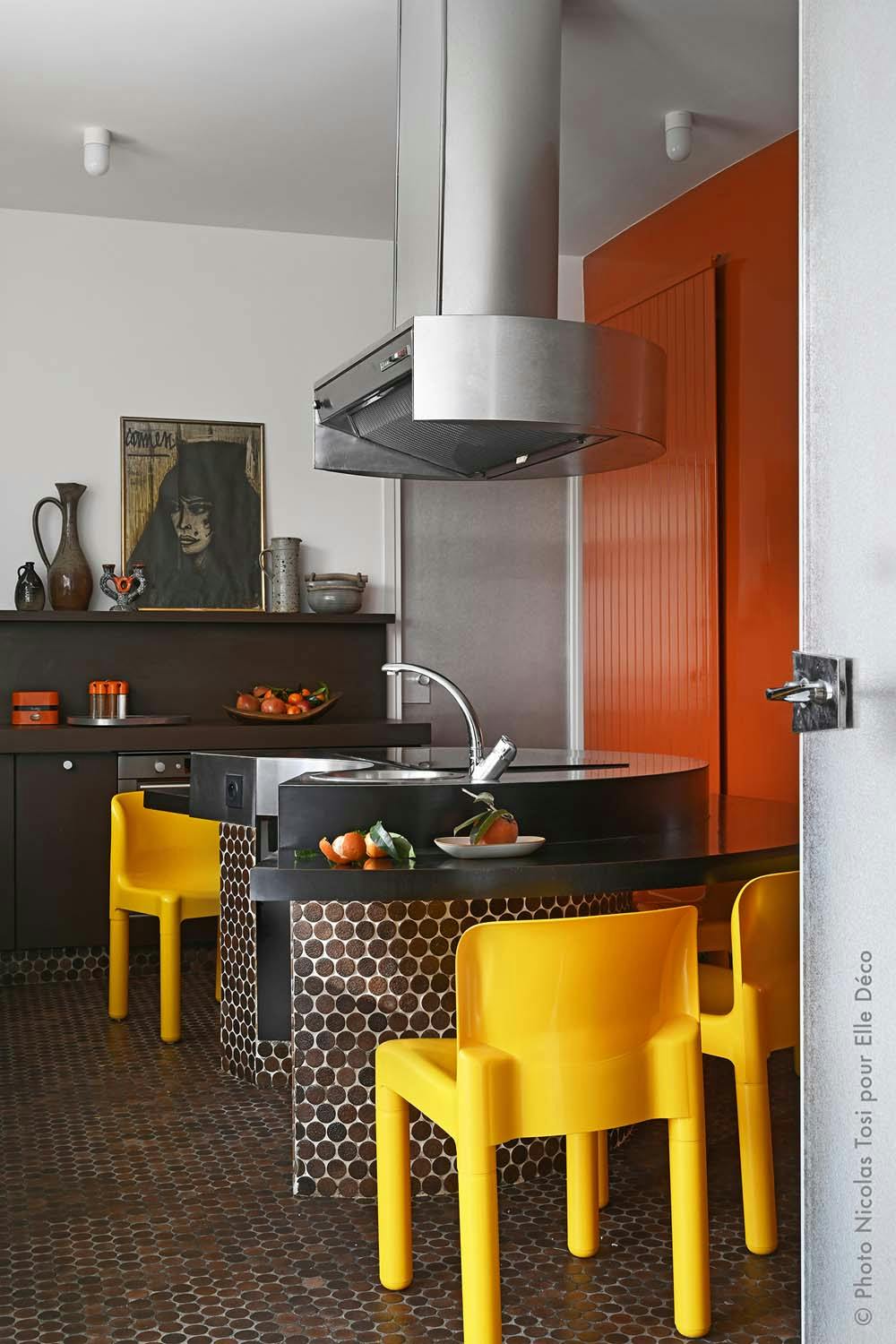 The kitchen of the villa: yellow chairs, work island