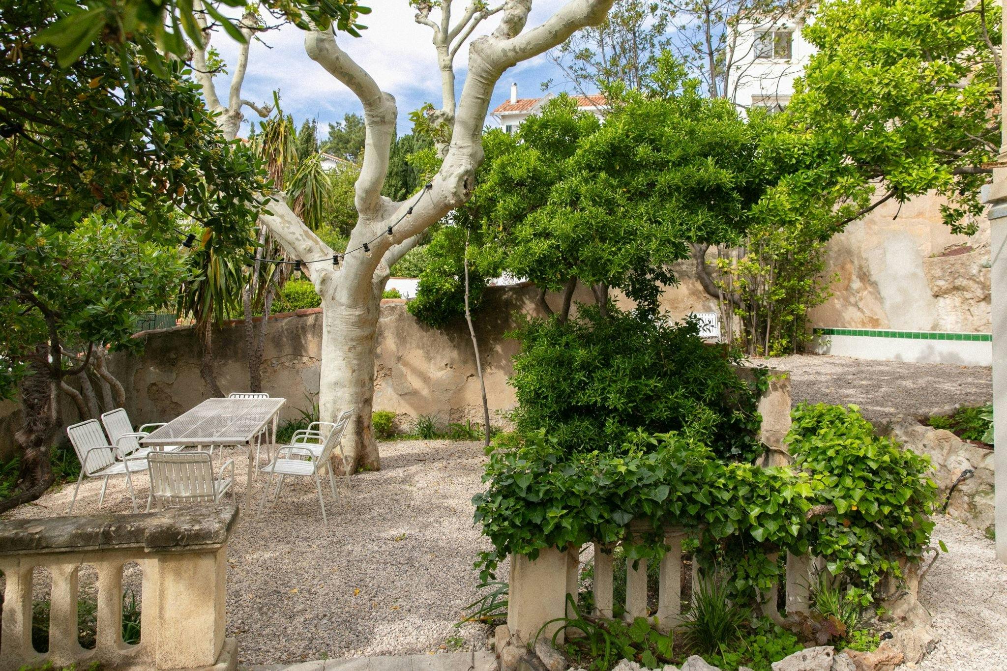 The garden: white wrought iron table, chairs, trees