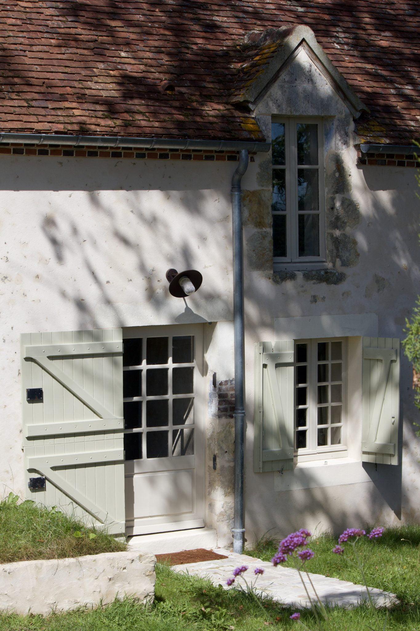 Entre les arbres, apparaît Une Maison dans le Perche. 