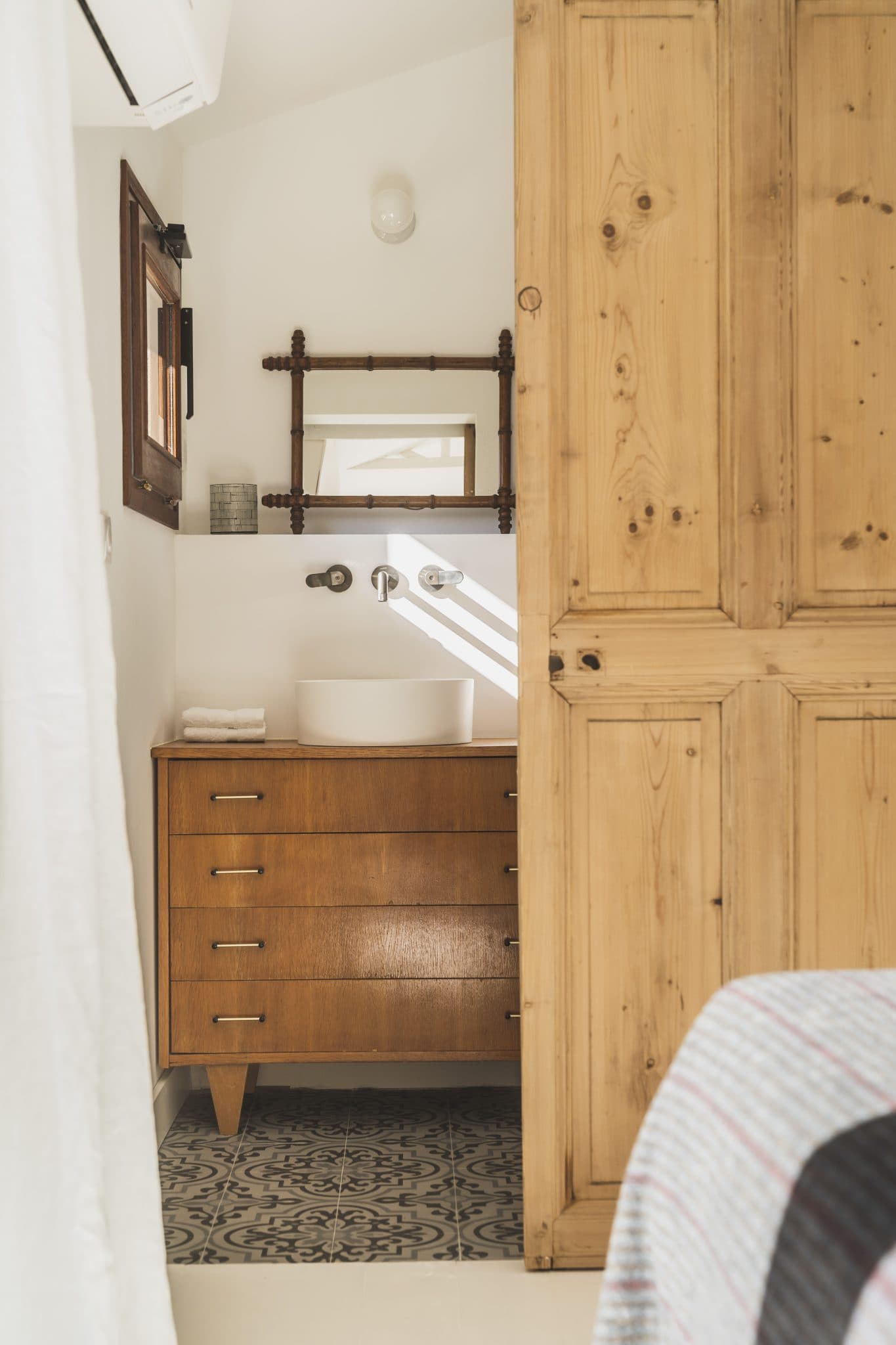 The wooden door separating the bedroom and the bathroom