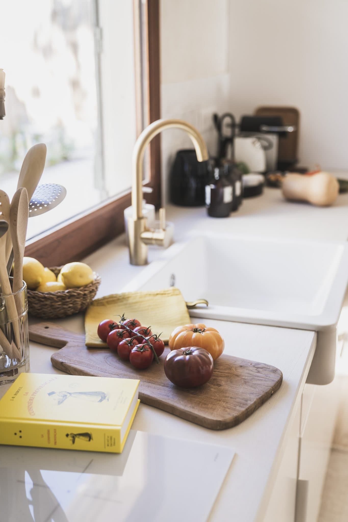 Le plan de travail de la cuisine : évier, tomates, livre de cuisine