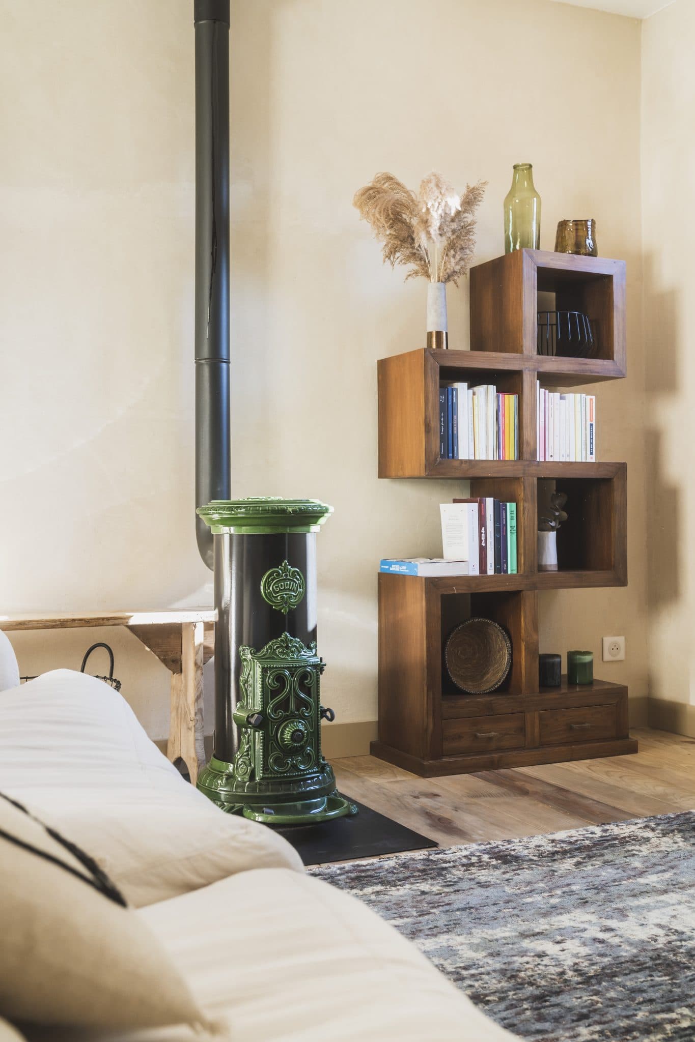 The living room of the house: stove, sofa, rug, bookshelf