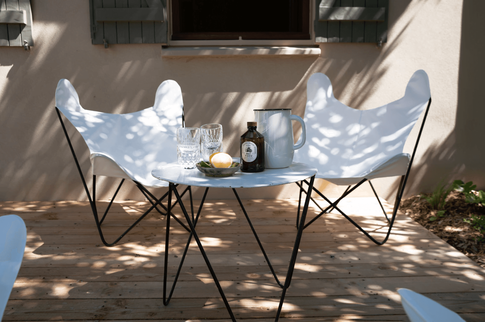 Garden furniture on the terrace: white armchairs, coffee table.