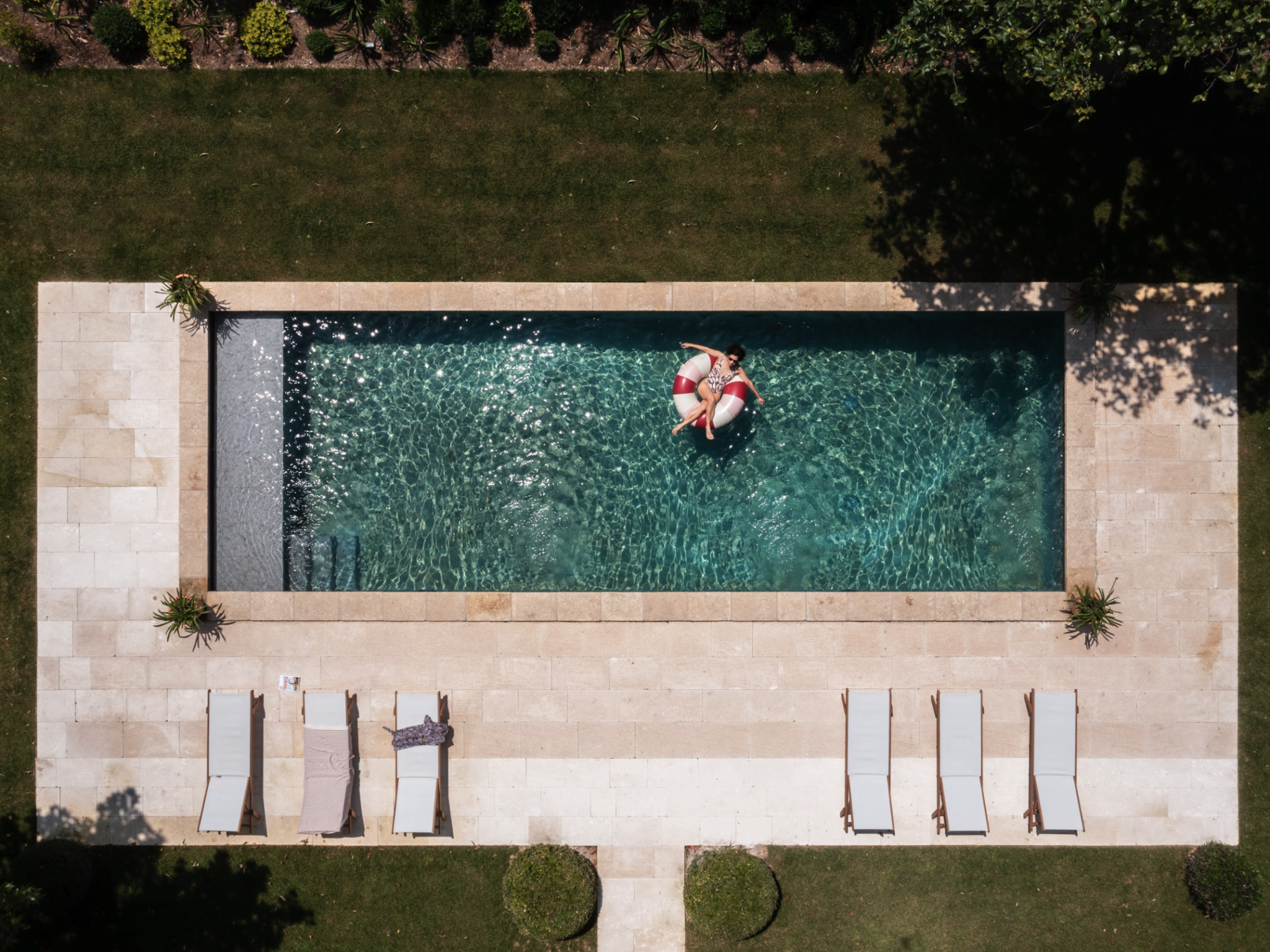 Piscine vue du ciel, pelouse, transats