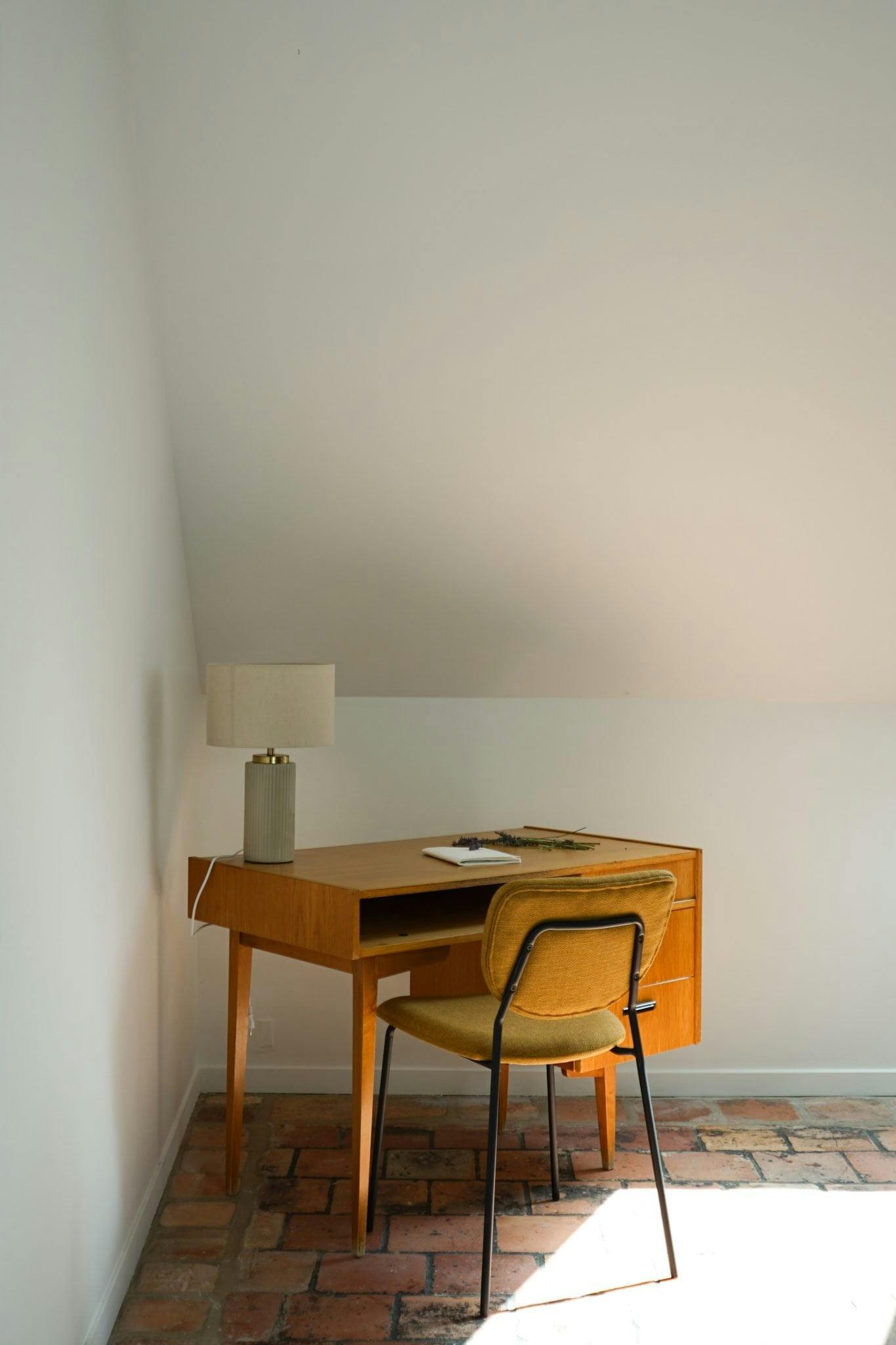 Wooden desk and chair in a corner of the room.