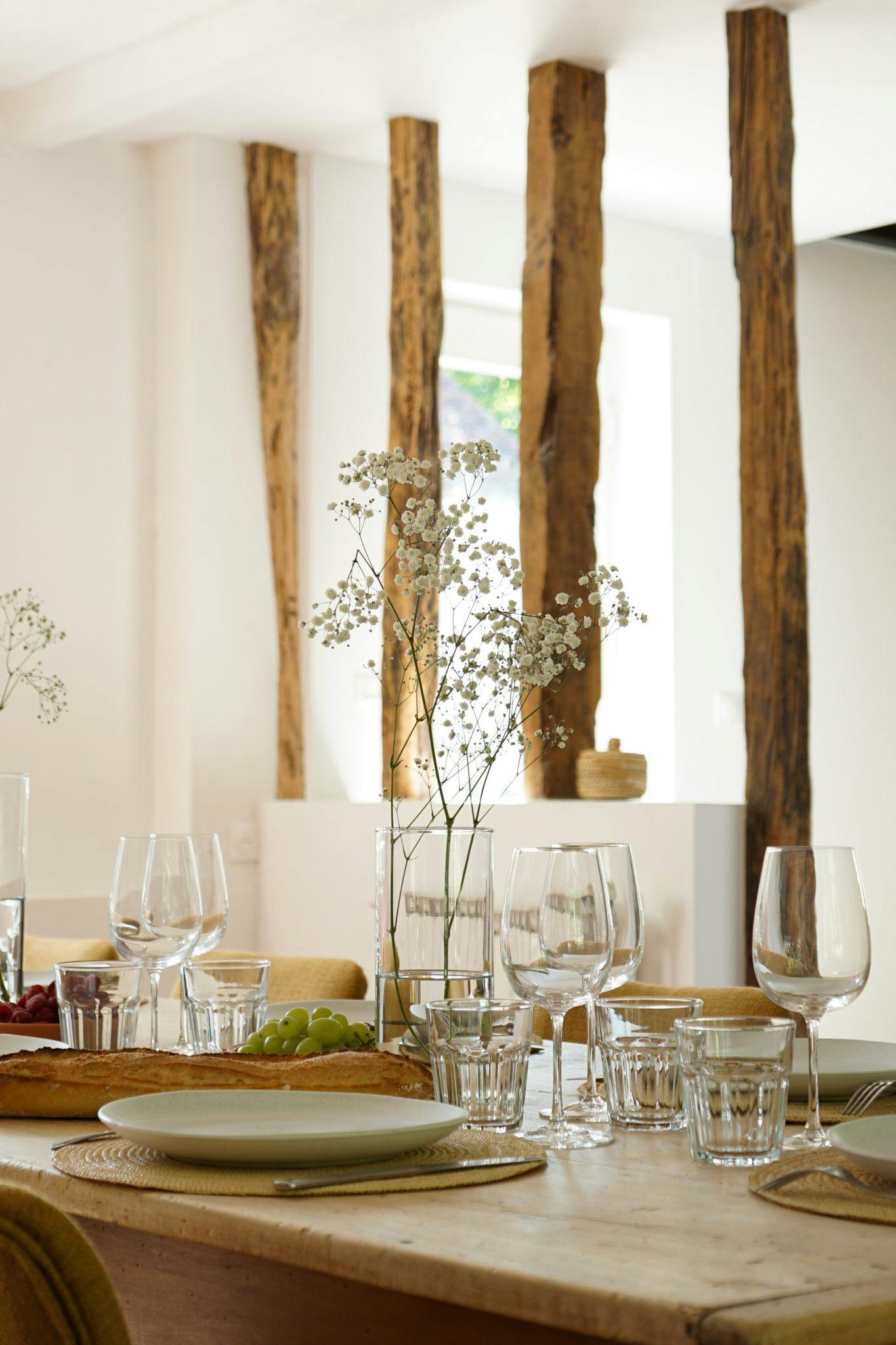 Dining table set, with wooden beams in the background.