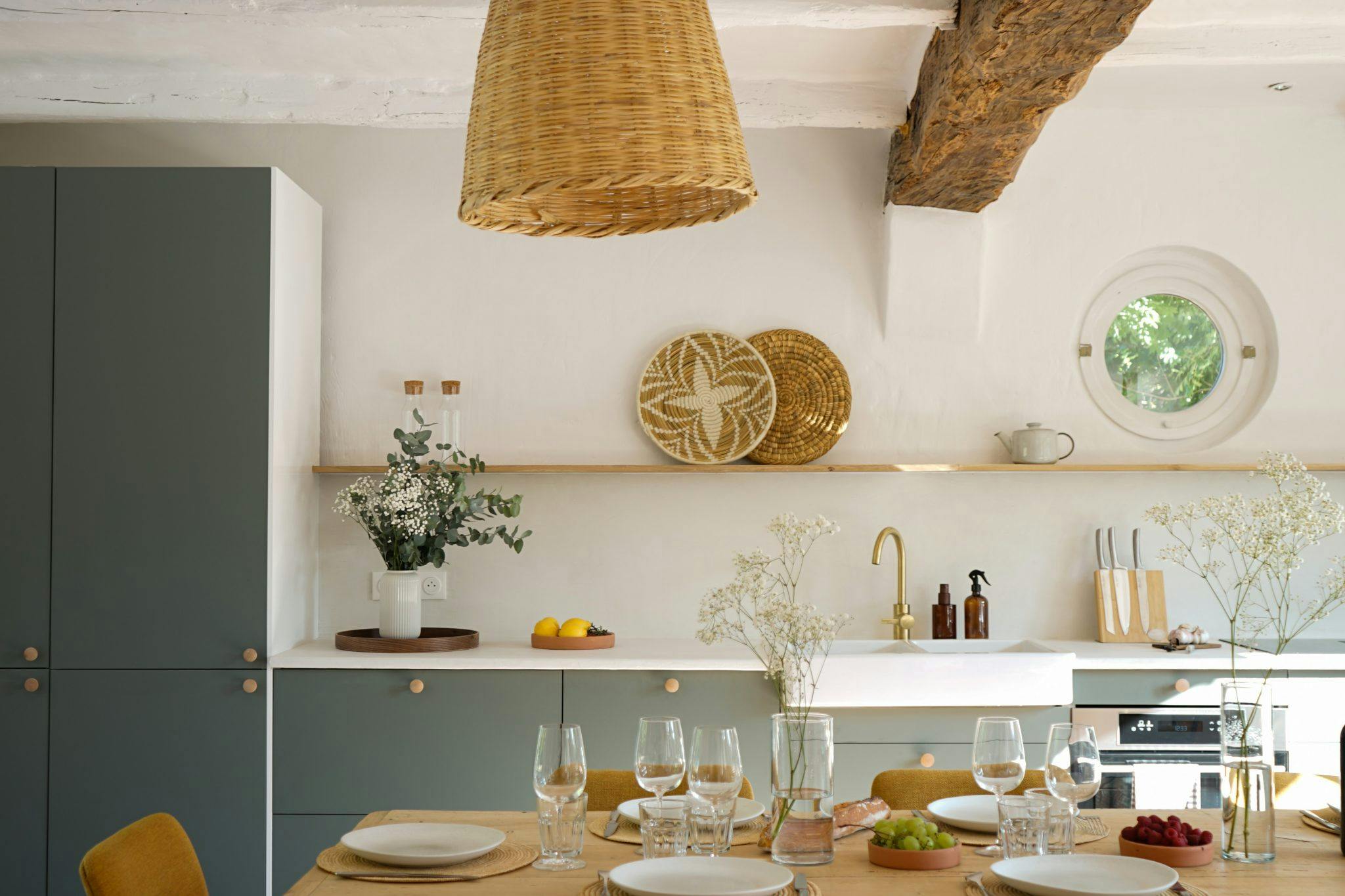 Cuisine salle à manger : grande table dressée, chaises, suspensions