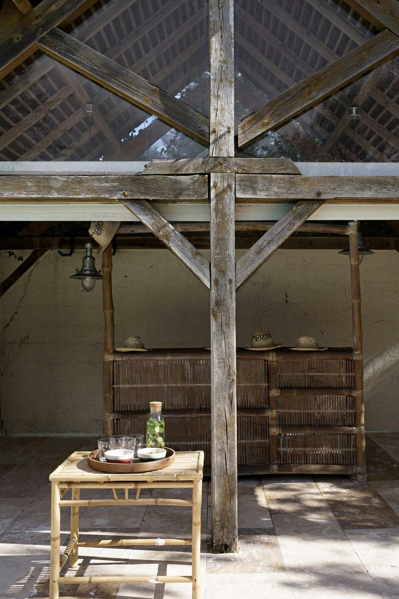 Pool house resembling a wooden cabin, with wooden table and chairs.