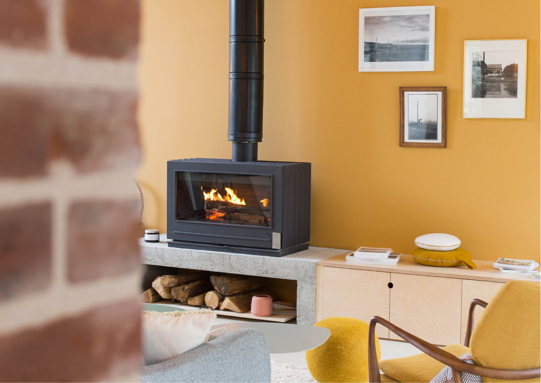 The stove in the living room, orange wall and paintings