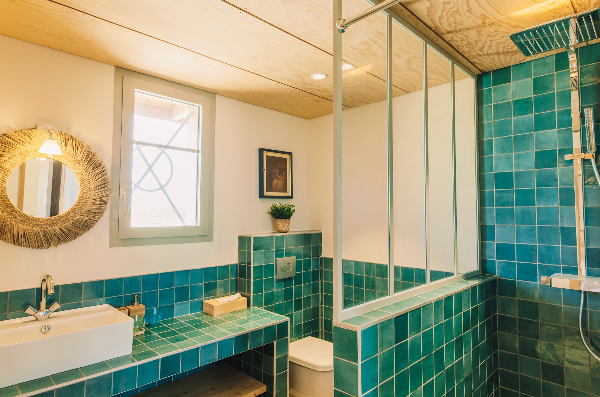 Bathroom with a walk-in shower adorned with green tiles and a sink.