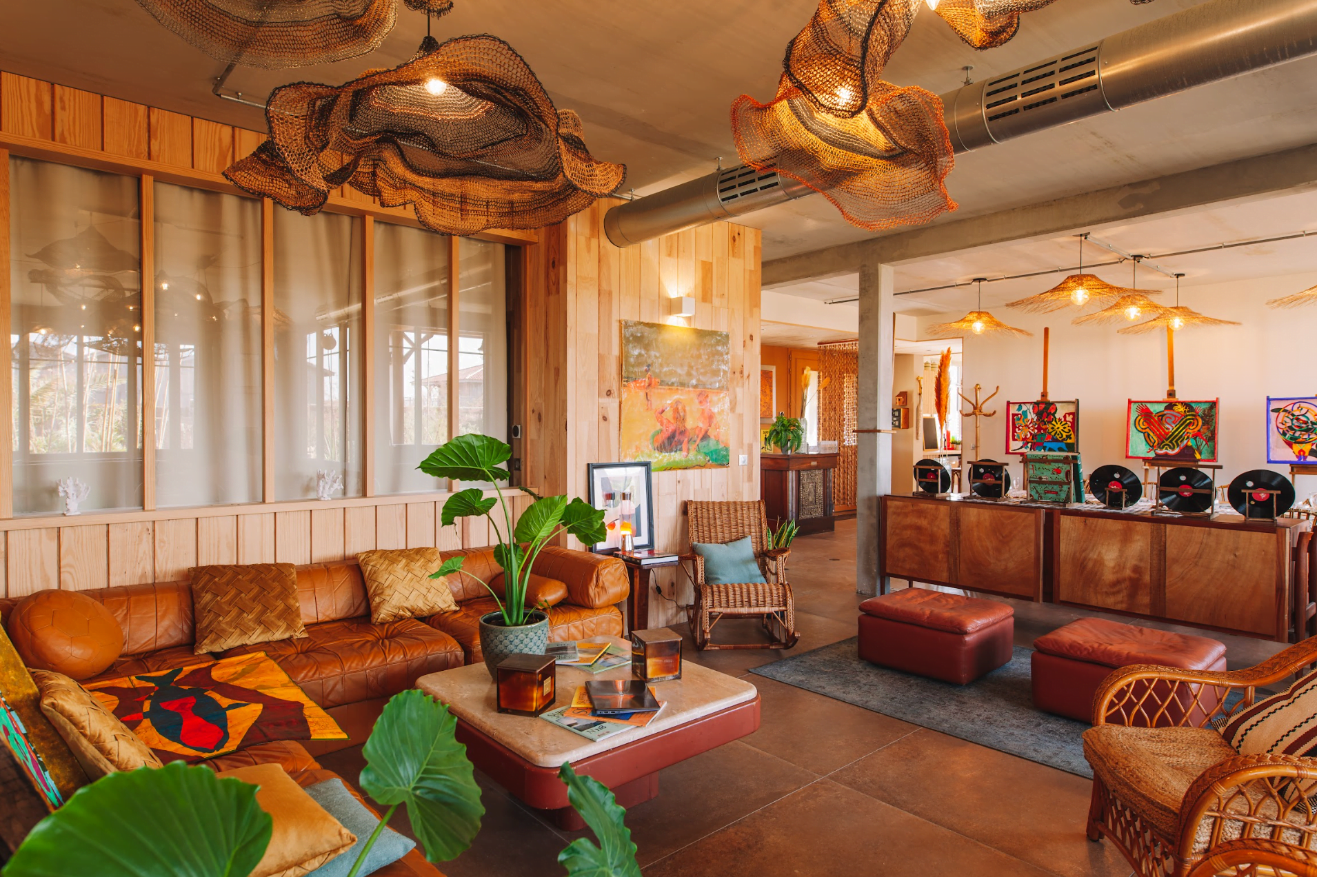 Living room with an orange leather sofa, coffee table, and pendant lights hanging from the ceiling.