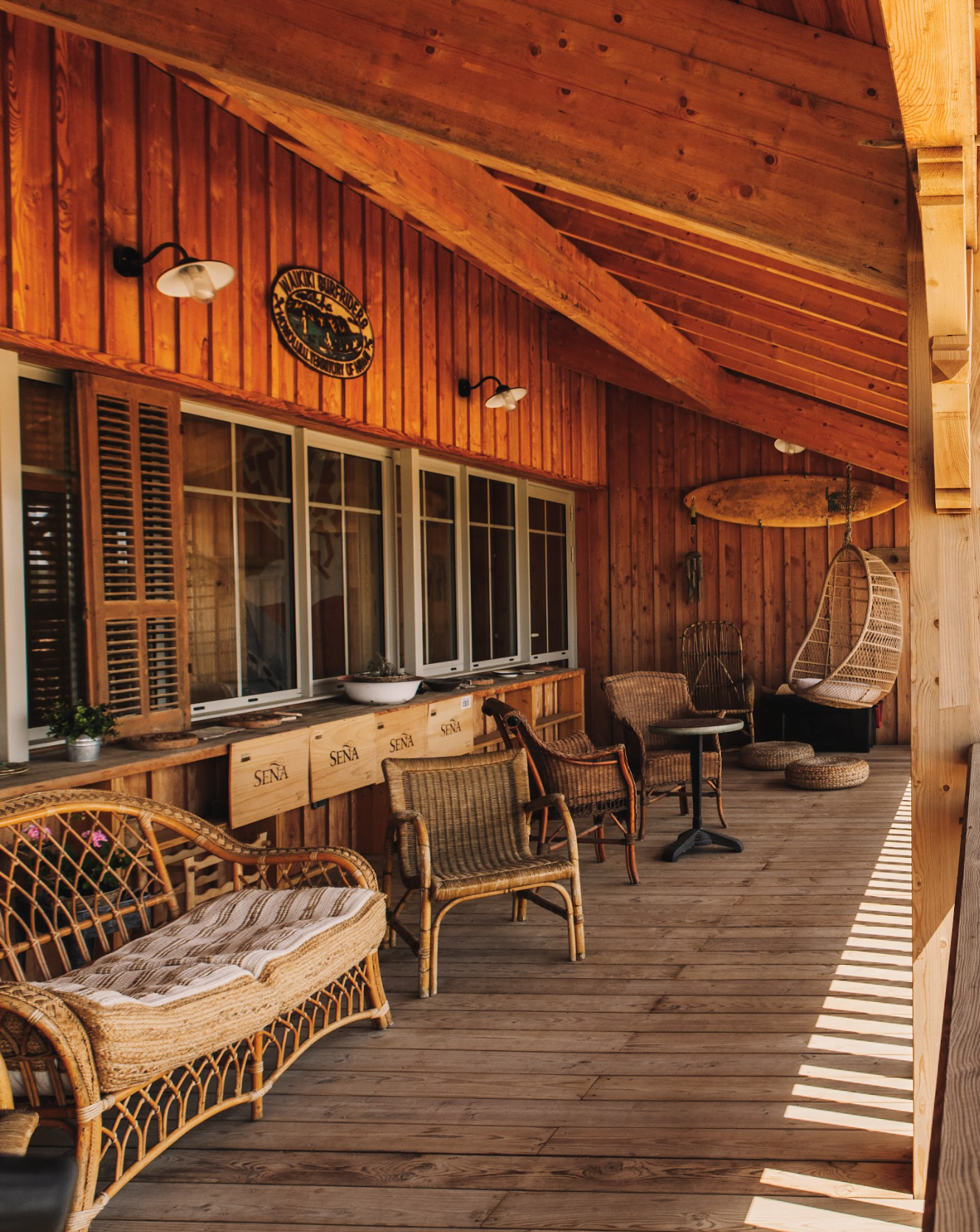 Wooden terrace, rattan chairs, and a glass wall.