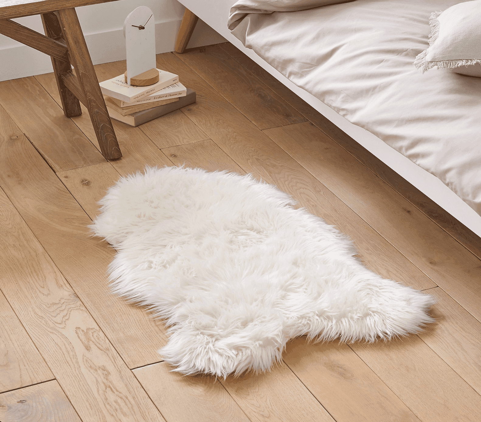 Tapis en fausse fourrure blanc sur du parquet 