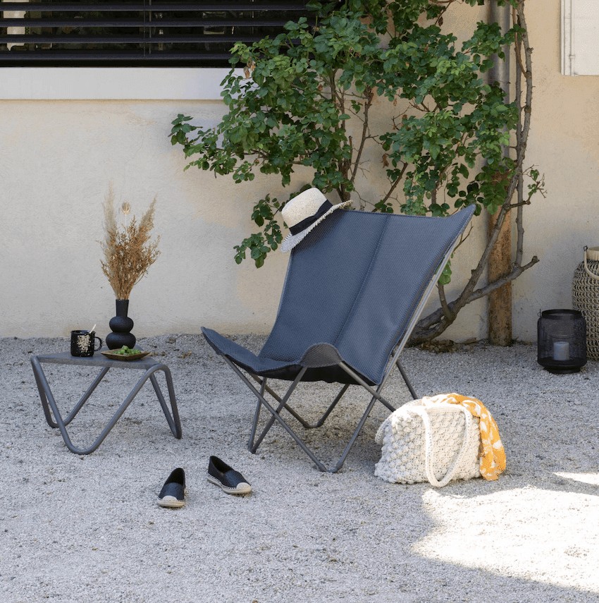 Fauteuil papillon gris dans un jardin