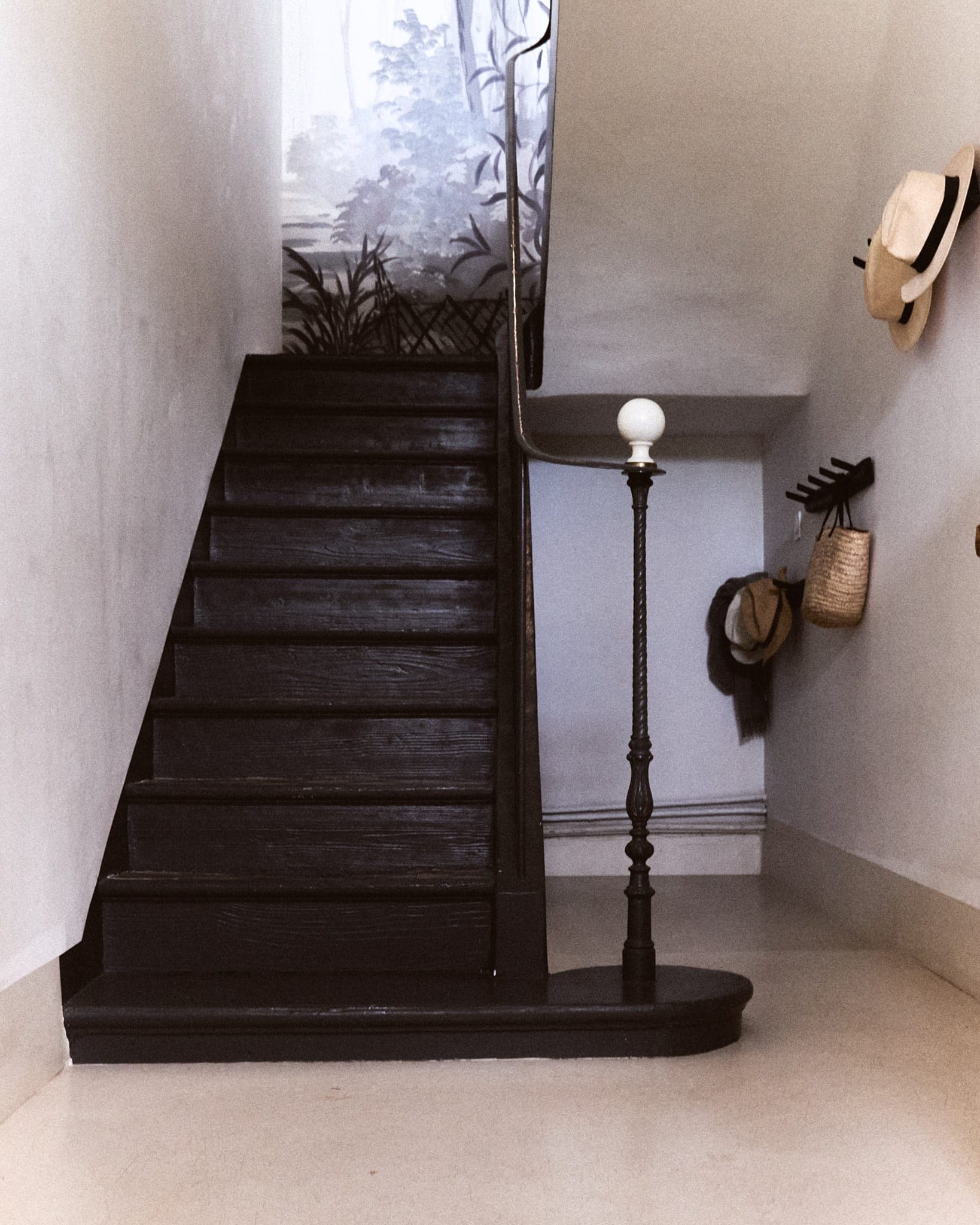 Harmony between the dark wooden staircase and the light, lime-washed walls.