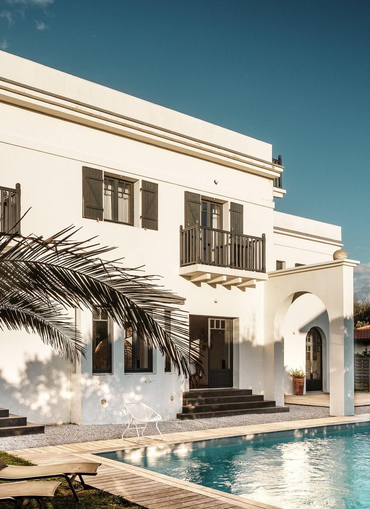view of the swimming pool and the house planted with palm trees